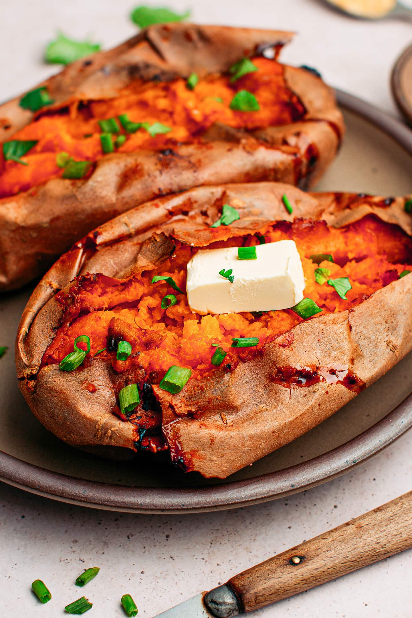 Close-up of smoked sweet potatoes topped with a knob of butter.