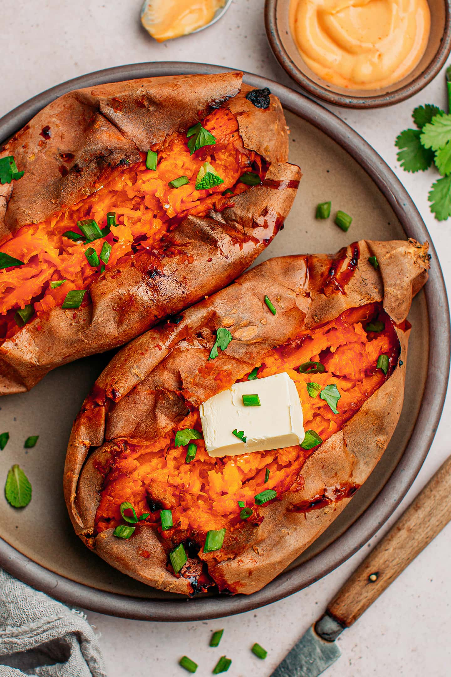 Sweet potatoes topped with chopped green onions and butter.