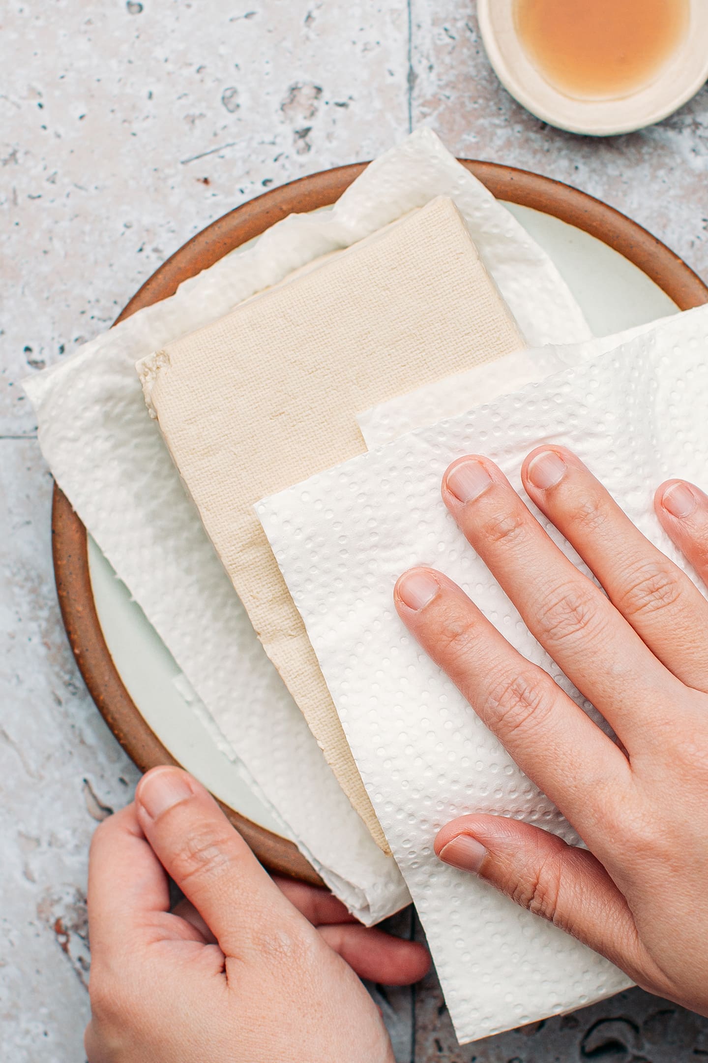 Patting dry a block of tofu.