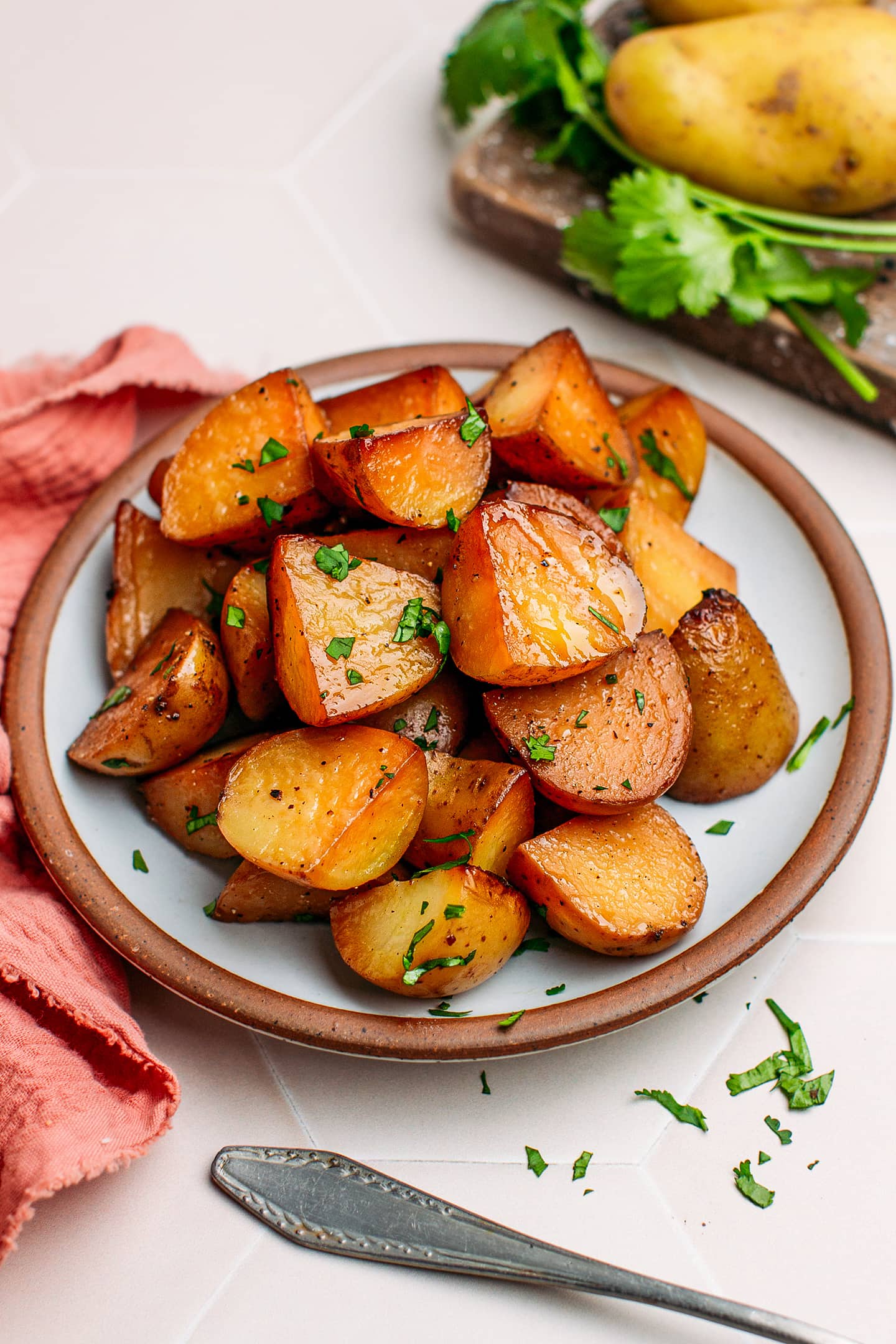 Smoked potatoes garnished with cilantro on a small plate.