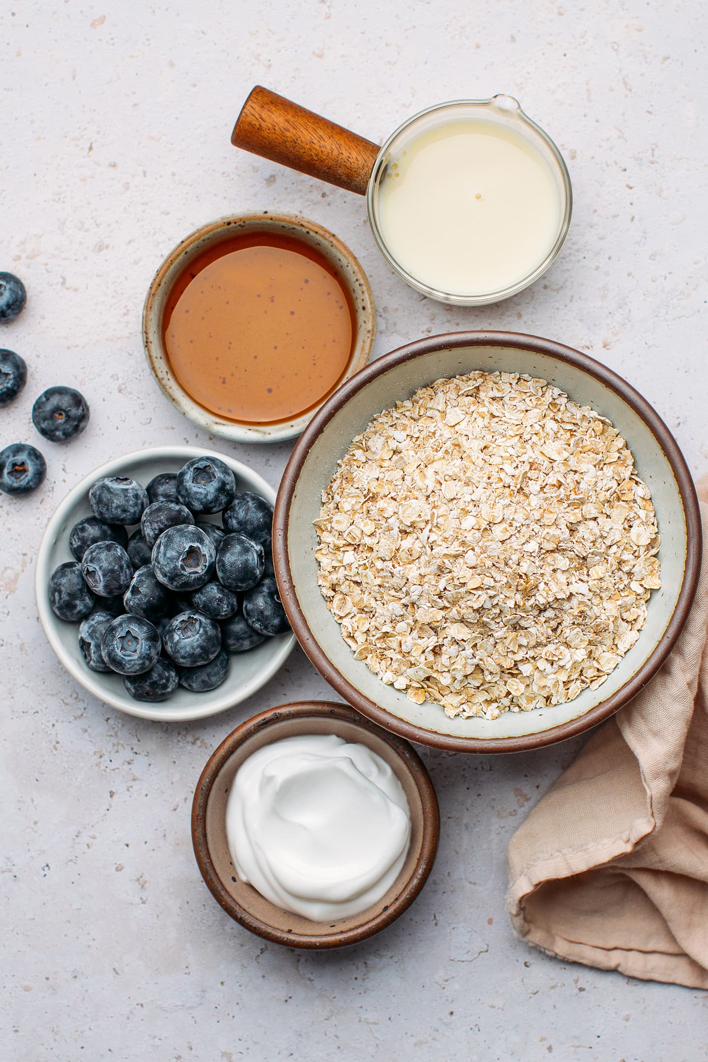 Ingredients like quick oats, blueberries, coconut yogurt, and maple syrup.