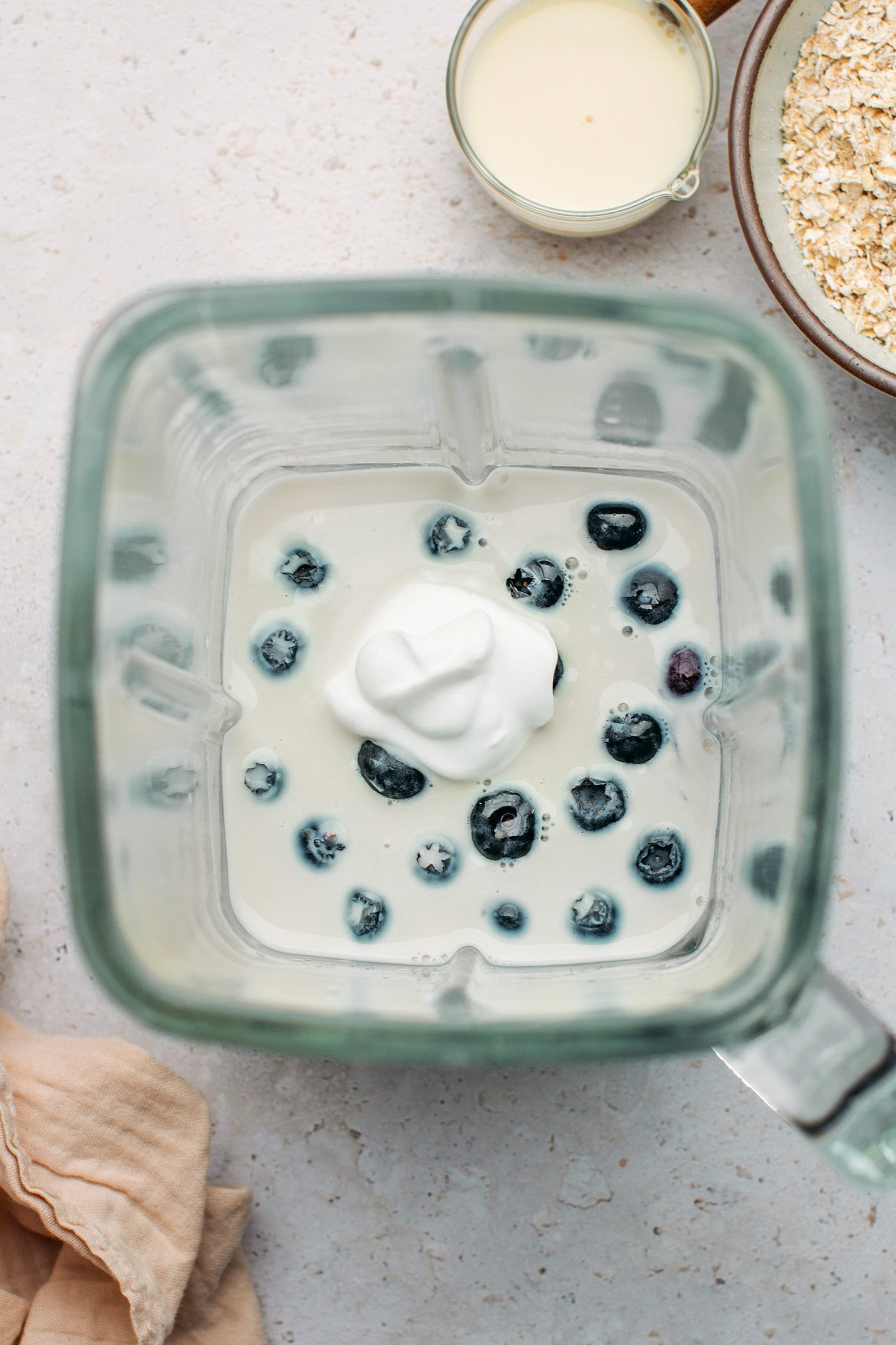 Milk, blueberries, and yogurt in a blender.