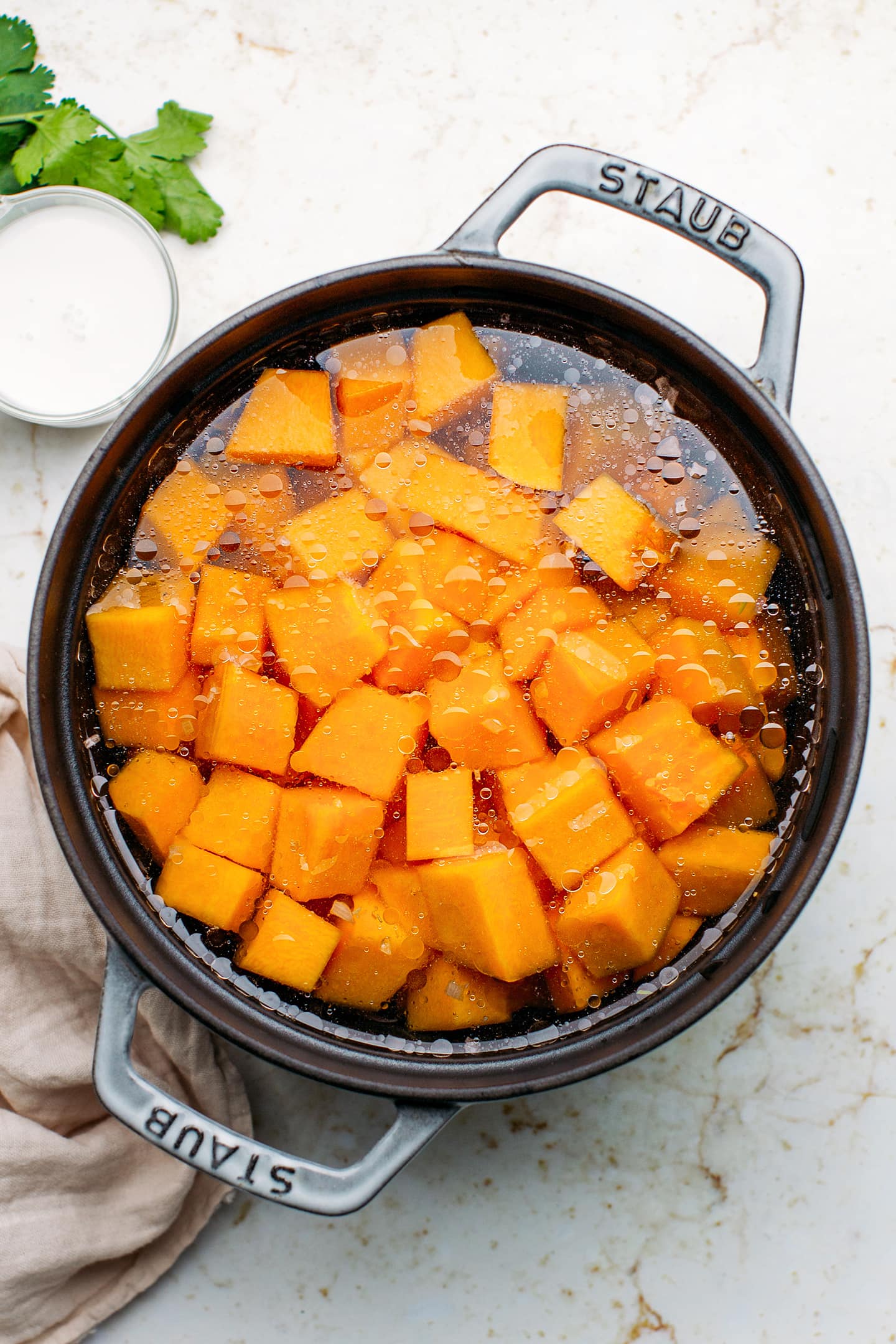 Cubed butternut squash in a pot filled with water.