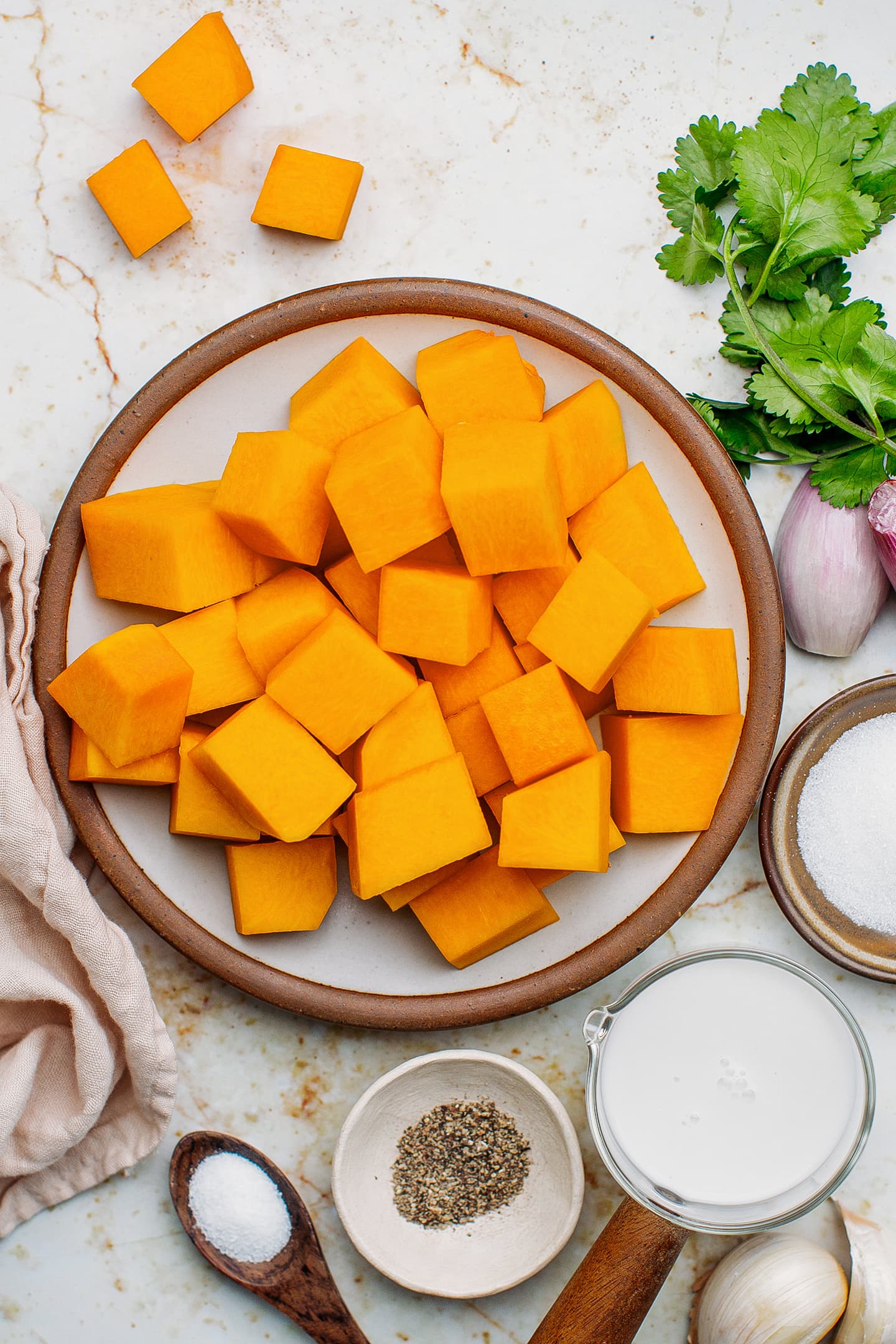 Ingredients like butternut squash, shallots, coconut milk, and ground black pepper.