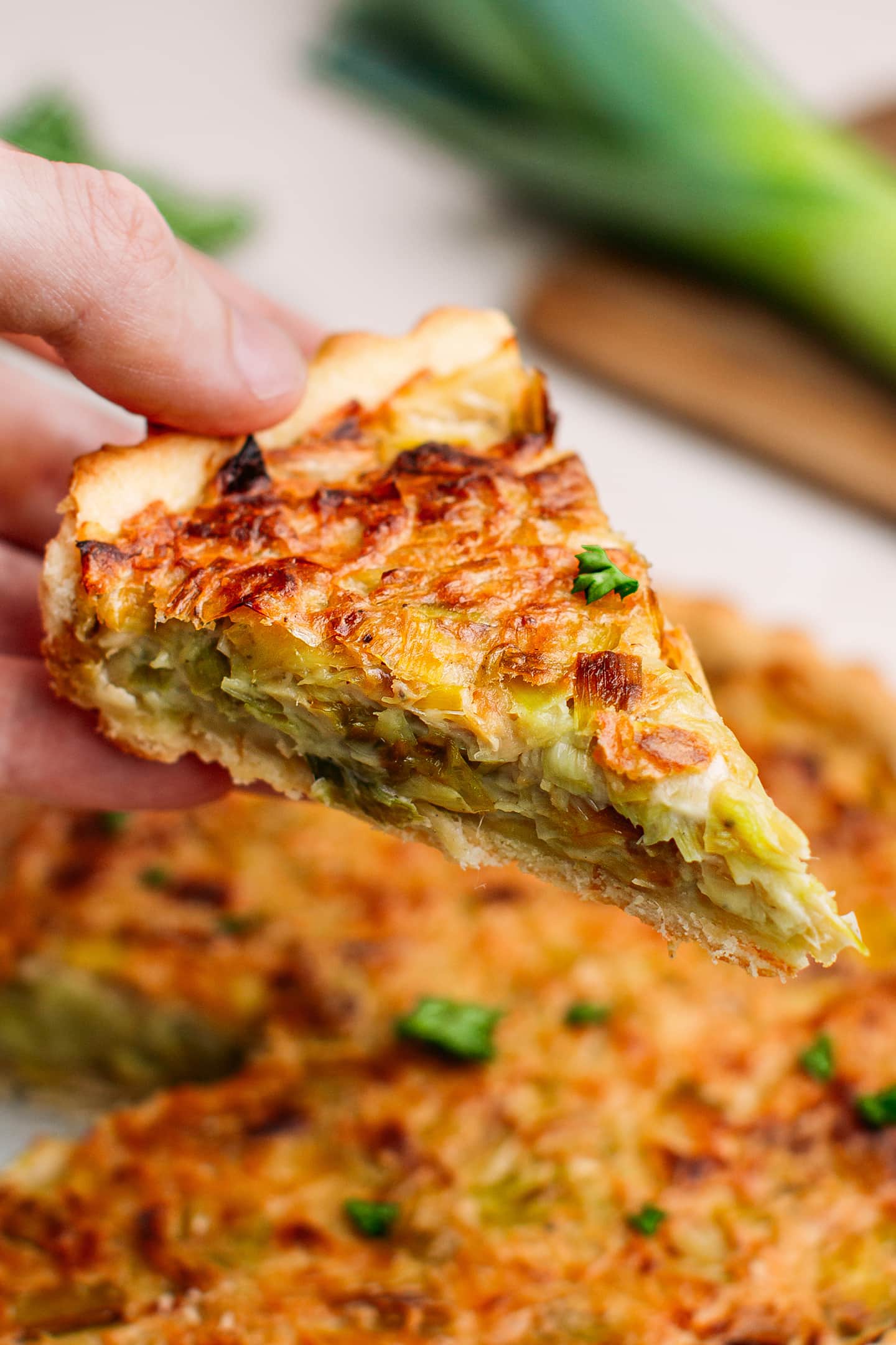 Holding a slice of leek tart.