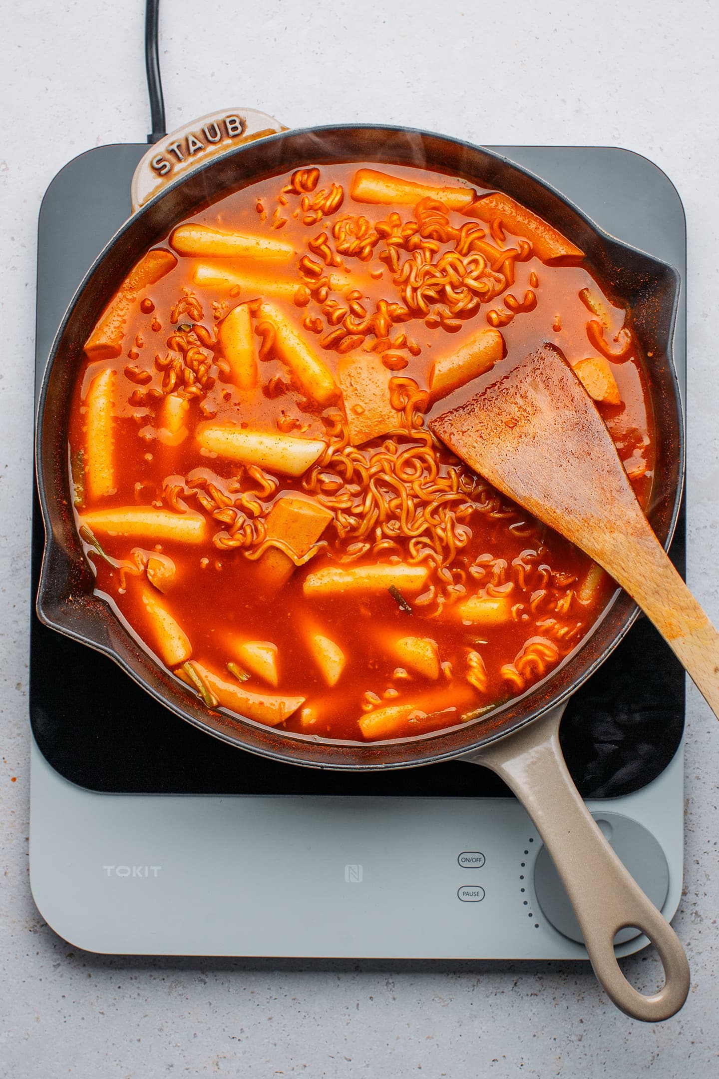 Instant noodles, vegan sausages, and tteokbokki in a skillet.