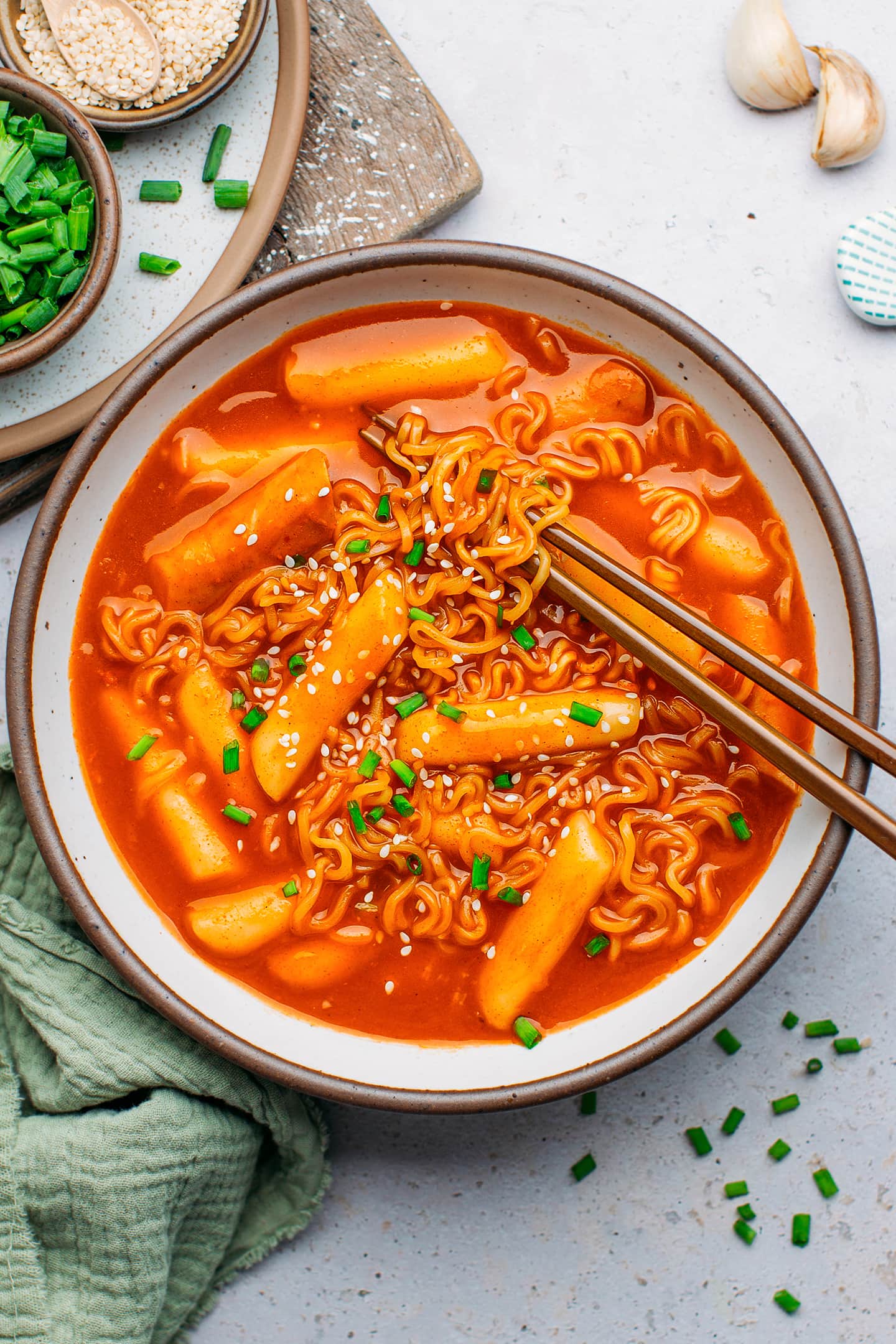 Tteokbokki and ramen noodles with green onions in a bowl.