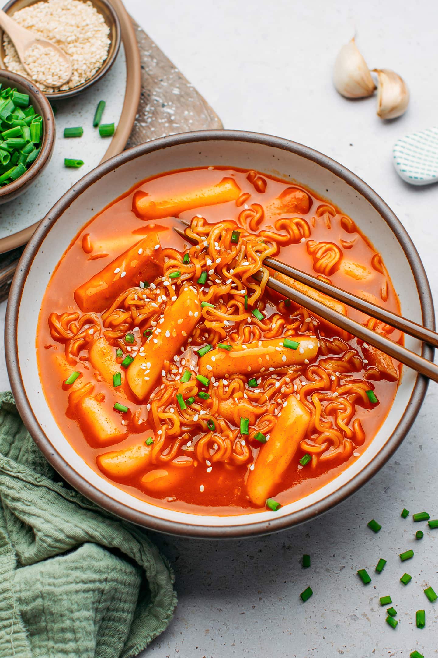 Rabokki topped with sesame seeds and green onions in a bowl.