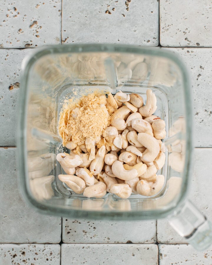 Raw cashews, nutritional yeast, and water in a blender.