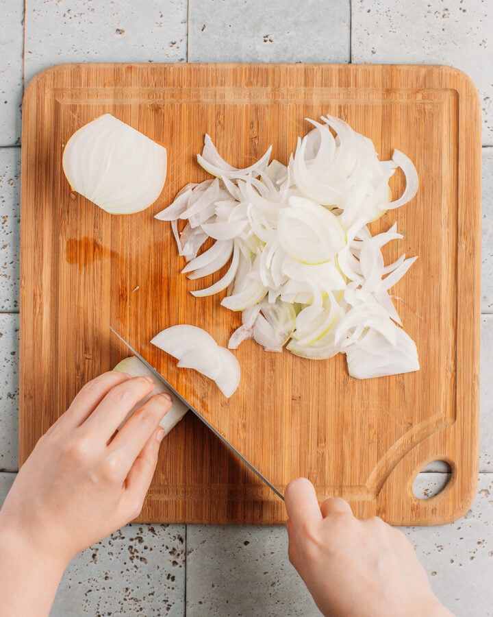 Slicing onions on a cutting board.