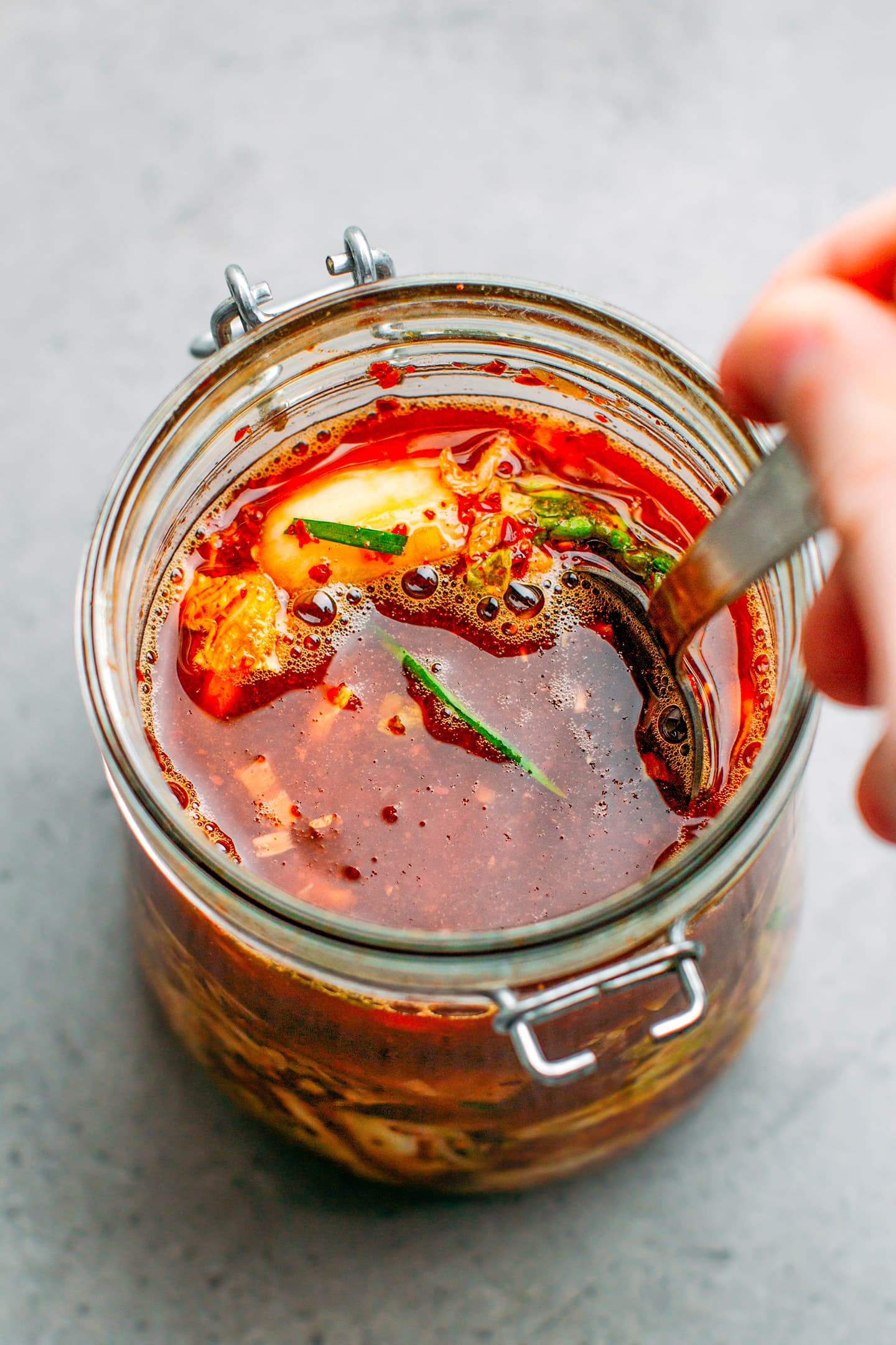 Kimchi in a jar with bubbles on the surface.