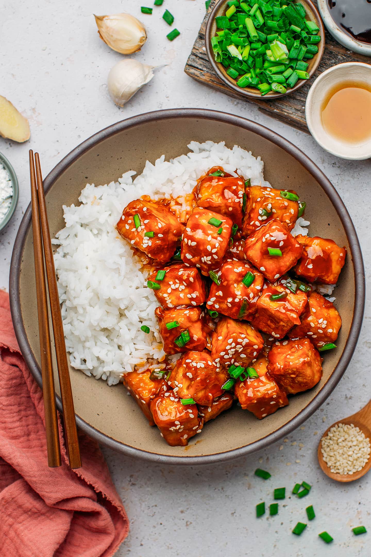 General Tso's tofu with white rice in a bowl.