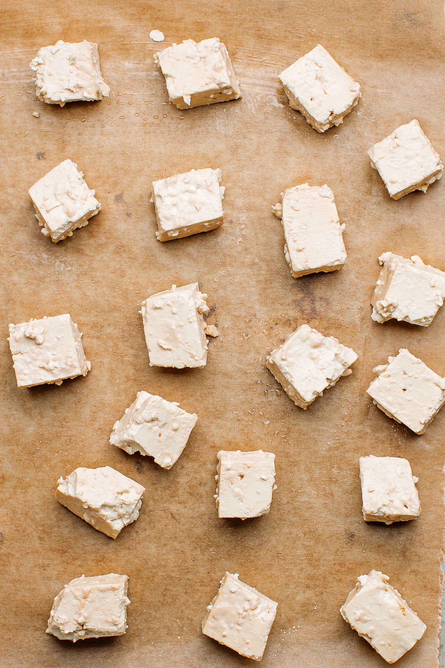 Tofu coated with cornstarch on a baking sheet.