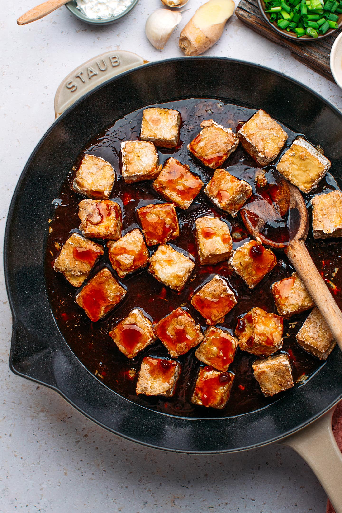 Baked tofu with general tso sauce in a skillet.