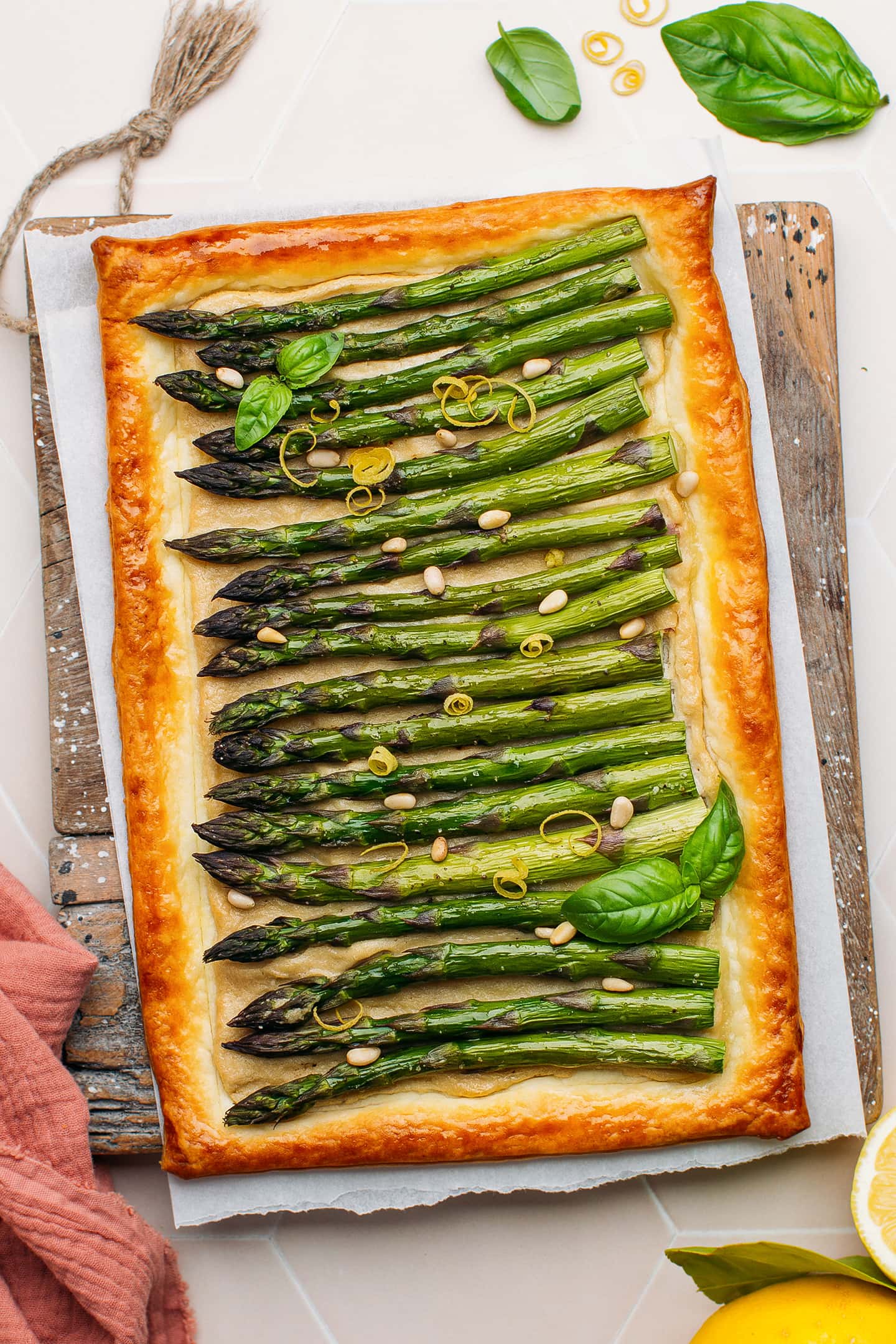 Tart with asparagus spears and cashew cream cheese on a cutting board.