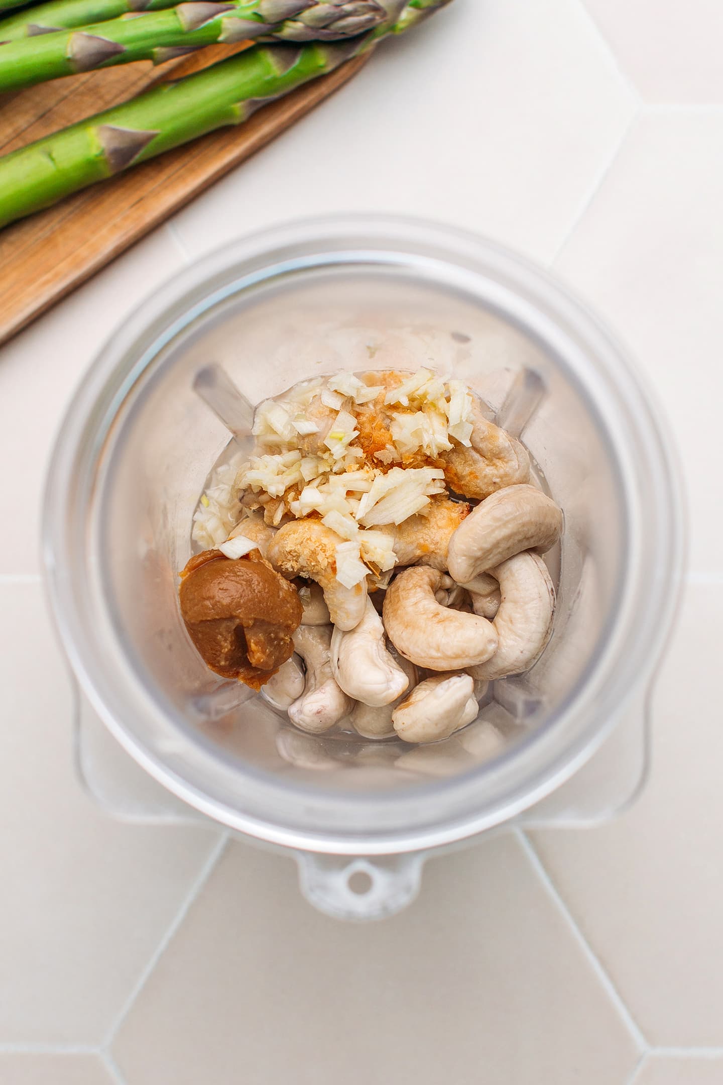 Raw cashews, miso, water, and garlic in a blender.