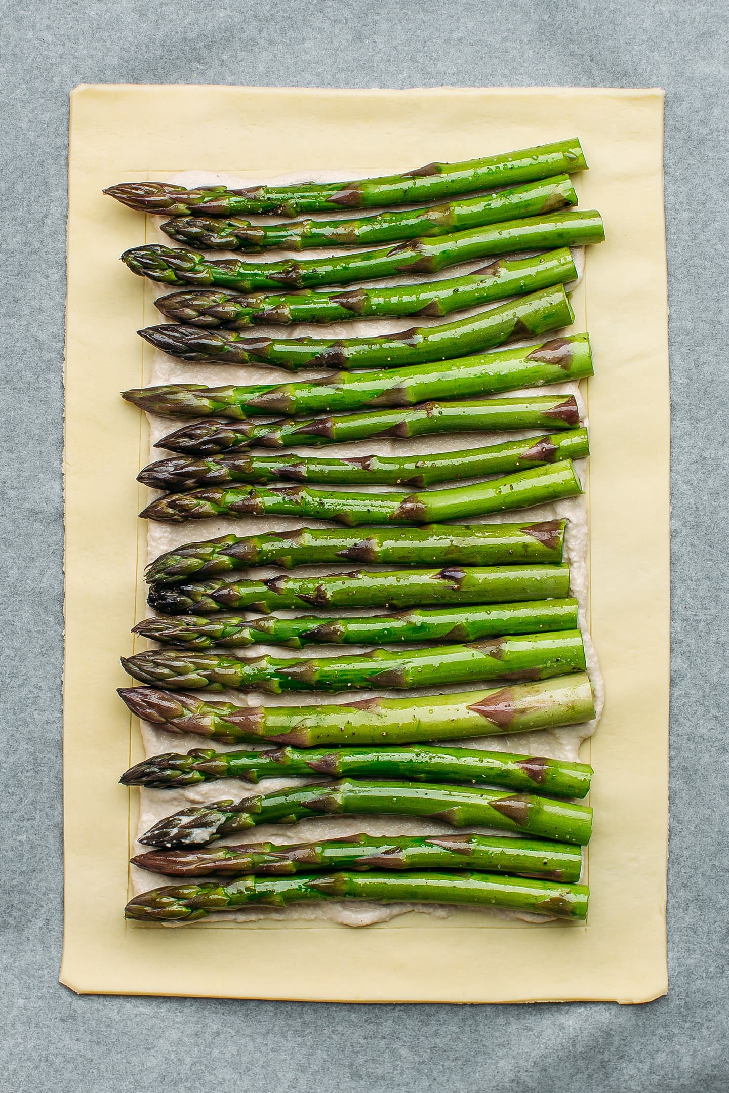 Unbaked asparagus tart on a baking sheet.