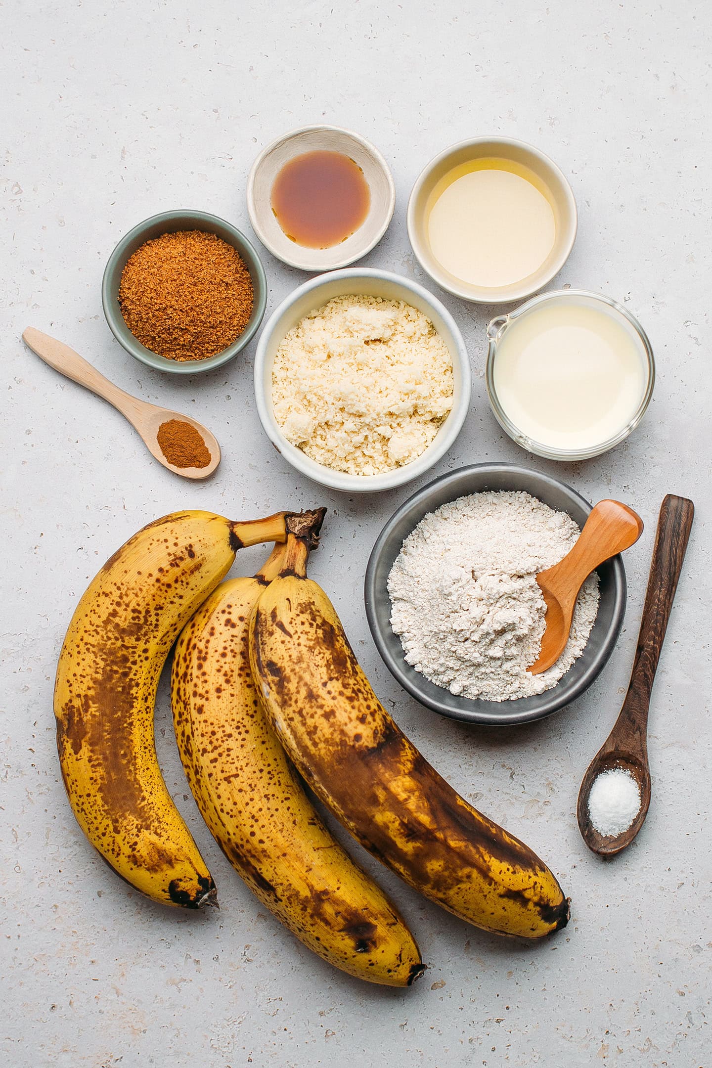 Ingredients like banana, oat flour, almond flour, coconut sugar, and milk.