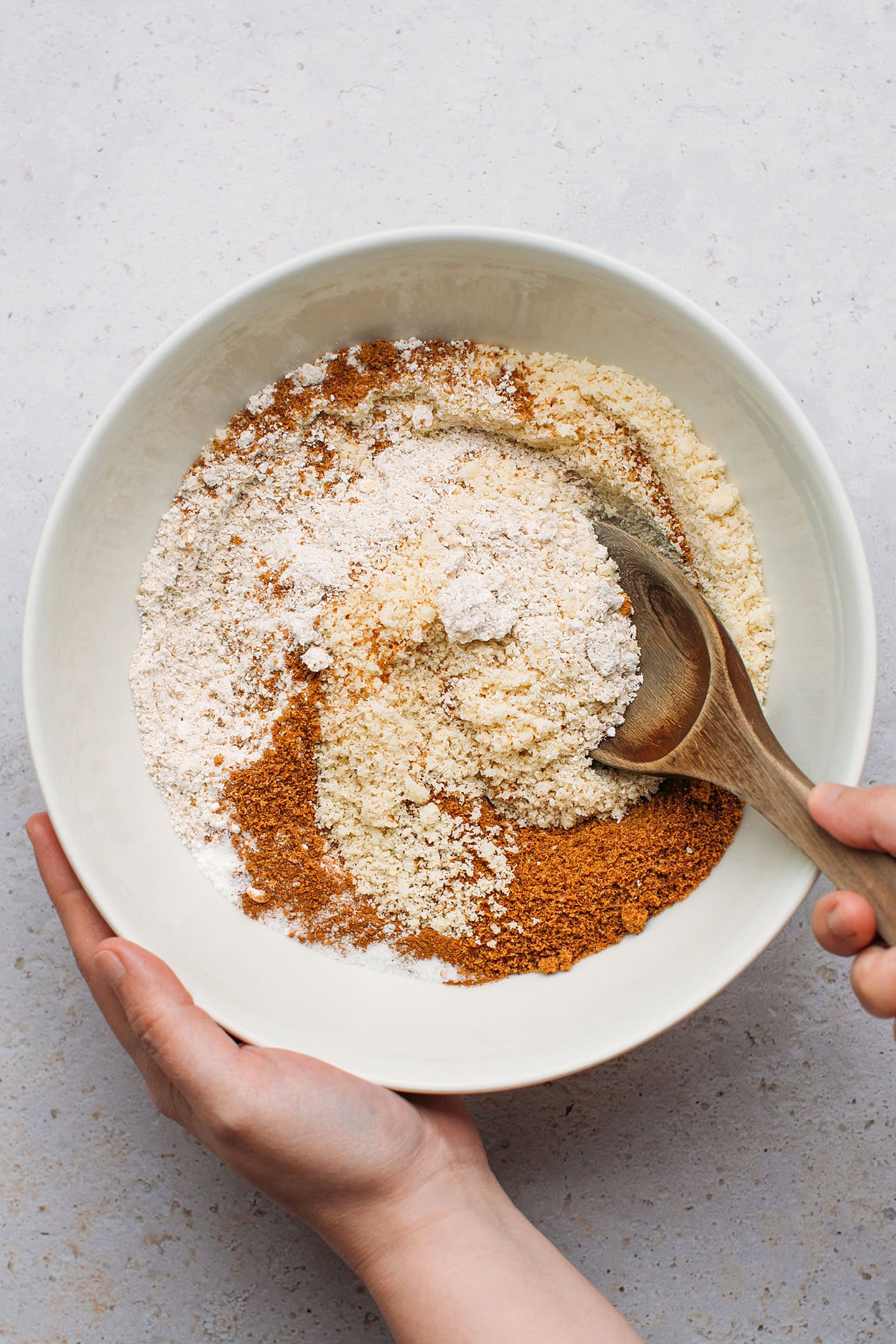 Whisking together oat flour, almond flour, and coconut sugar in a bowl.