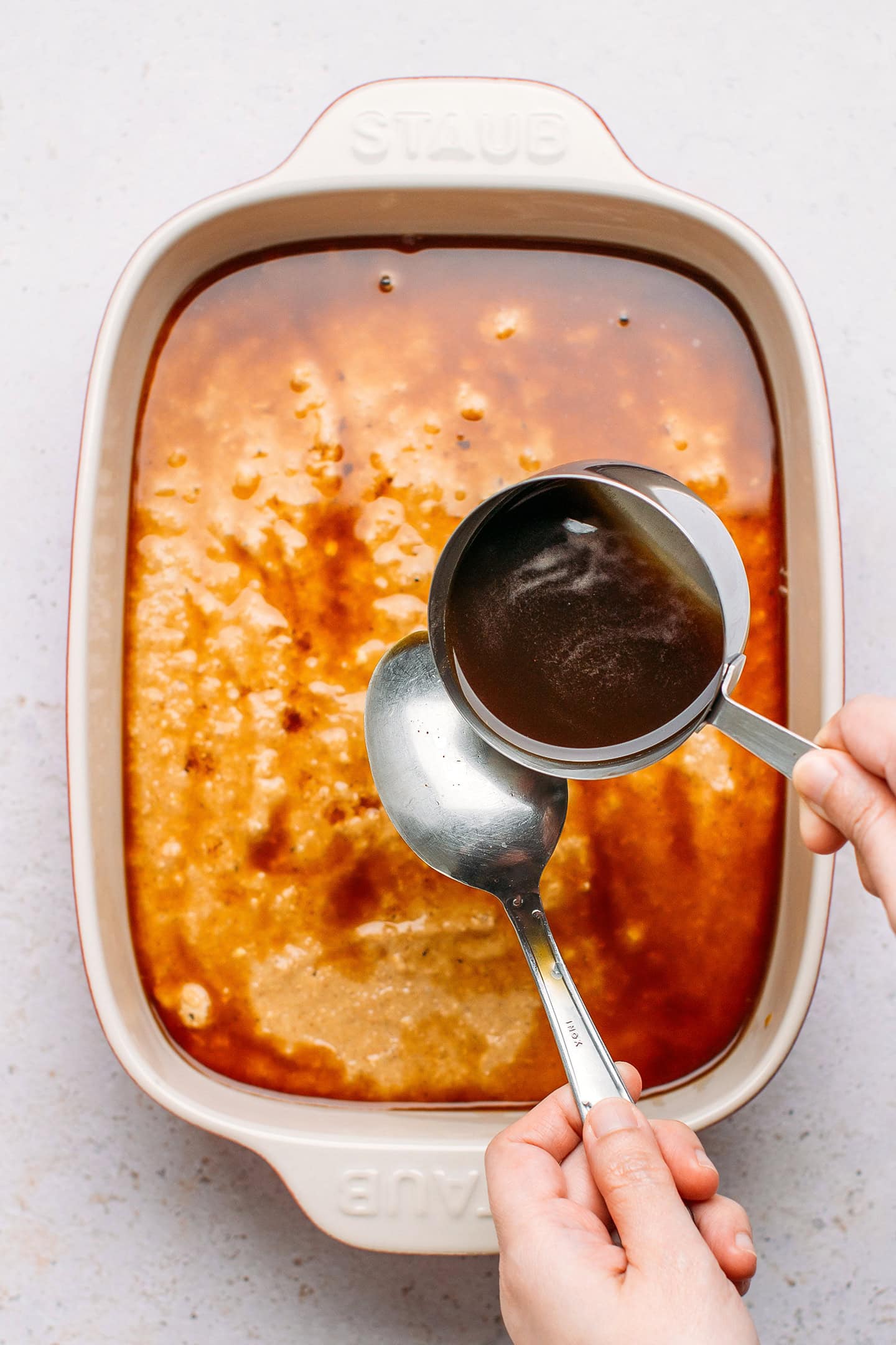 Pouring sweet sauce over the back of a spoon.