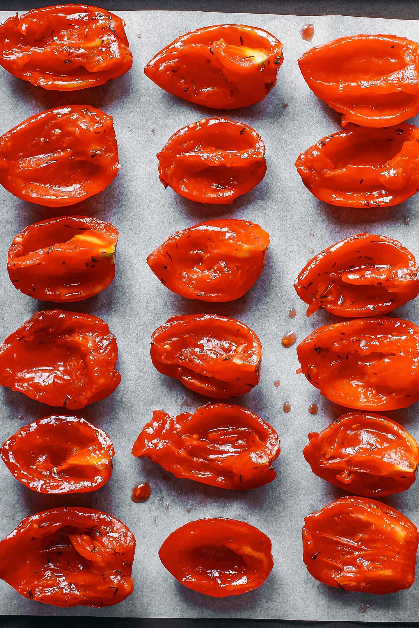 Quartered tomatoes on a baking sheet.