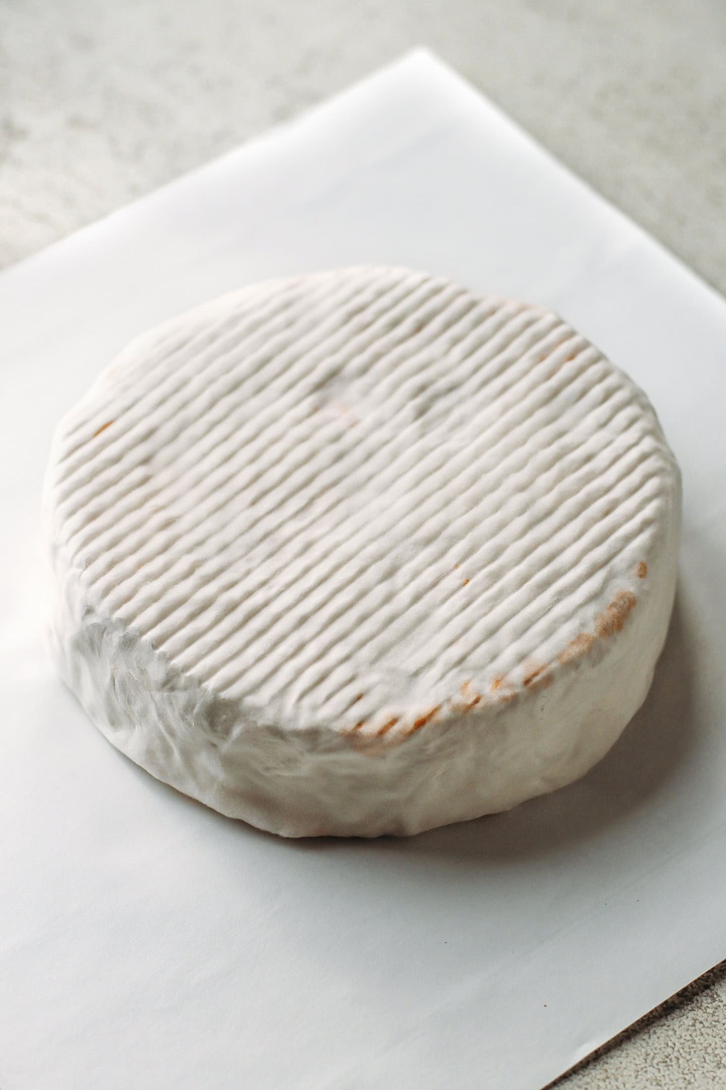 Tomato camembert coated with white mold.