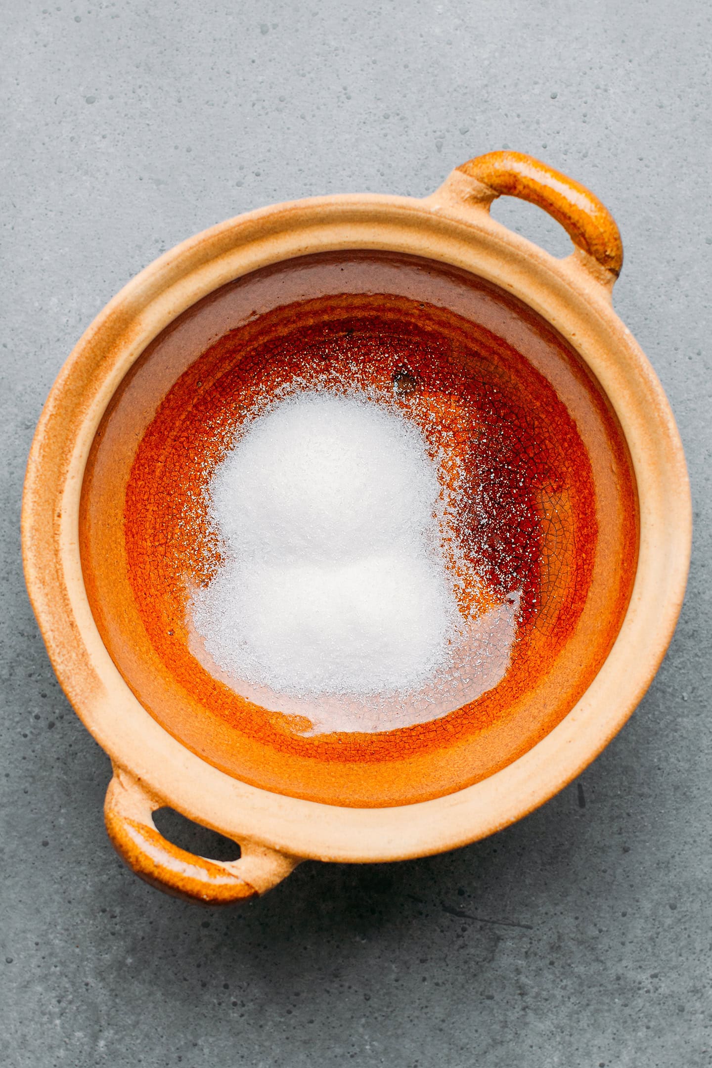 Granulated sugar in a clay pot.