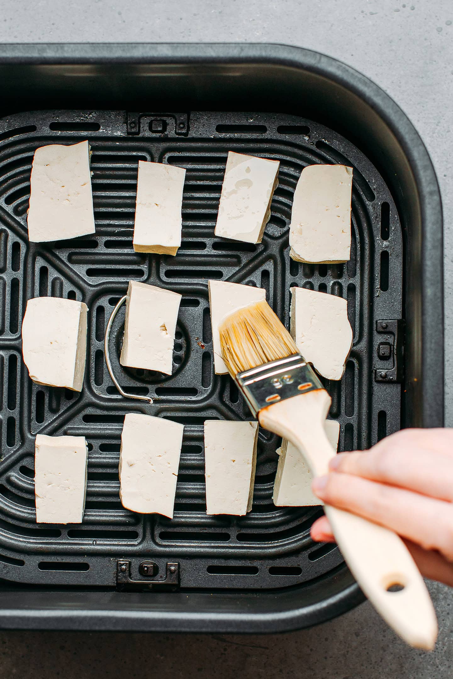 Brushing tofu cubes with oil.