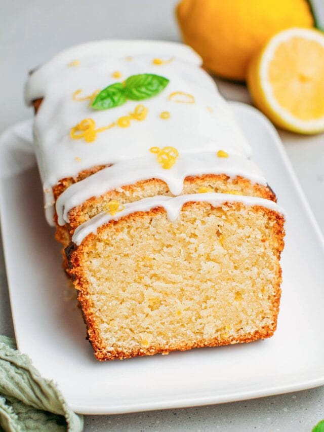 Lemon pound cake topped with lemon zest and basil leaves.