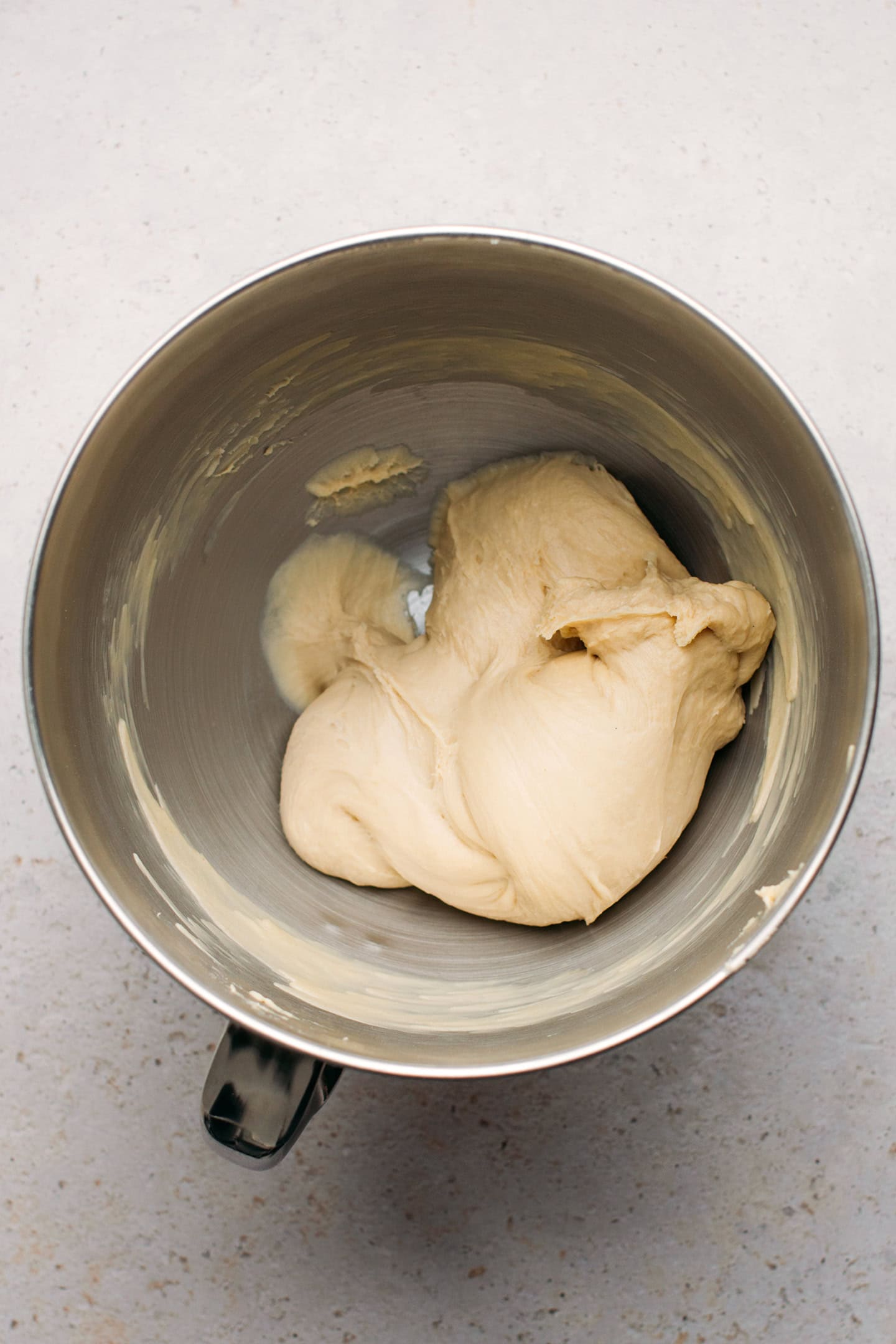 Smooth brioche dough in the bowl of a stand mixer.