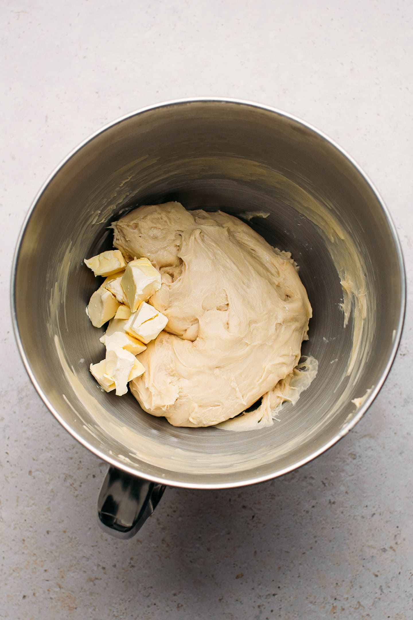 Dough and diced butter in a stand mixer.