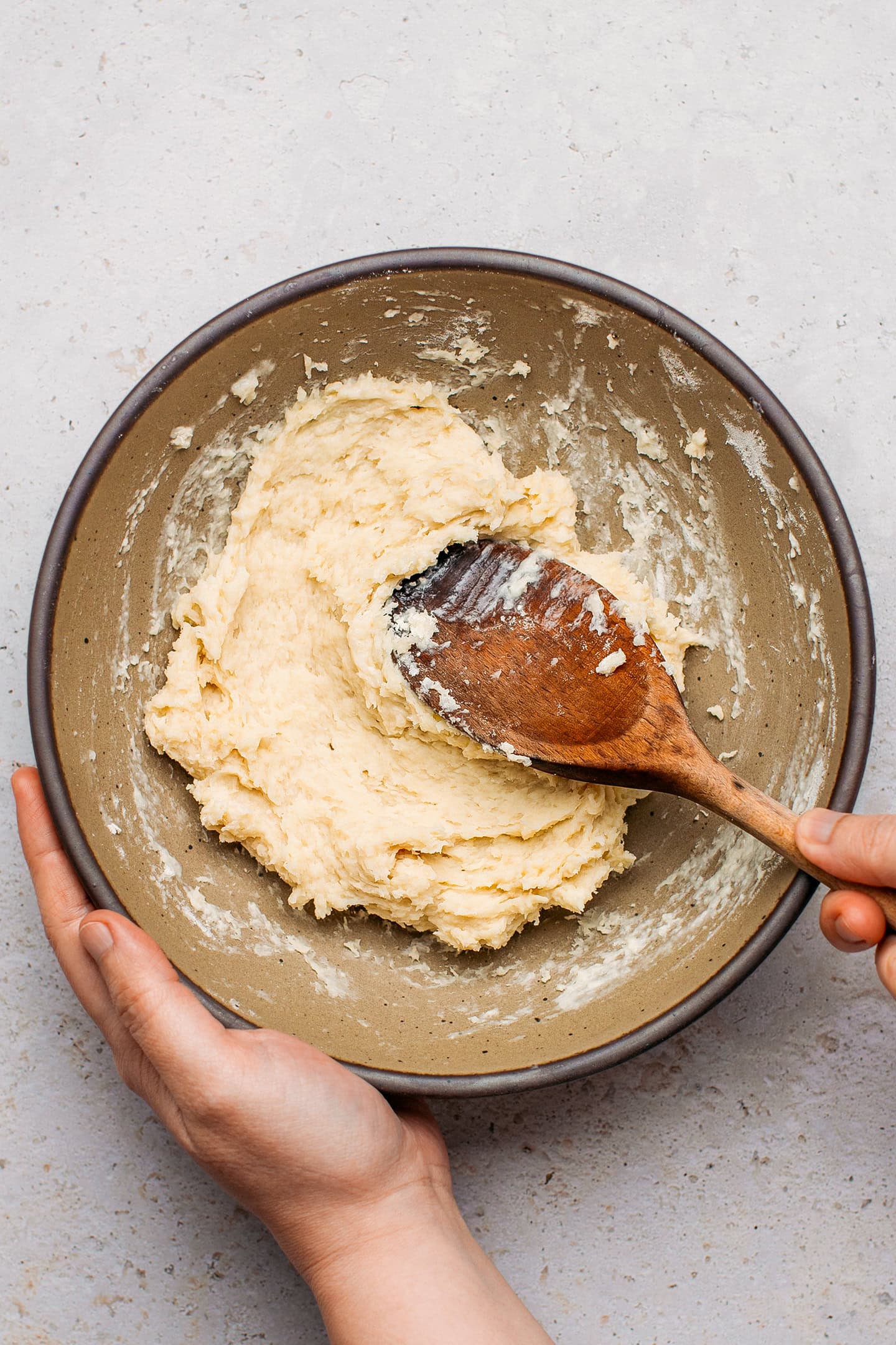 Mixing flour with water in a bowl.