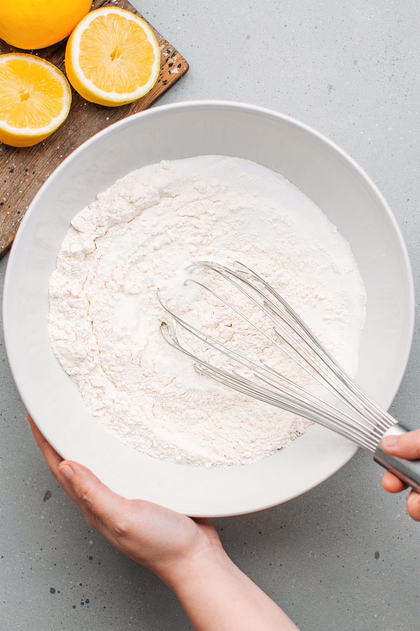 Whisking flour and sugar in a mixing bowl.