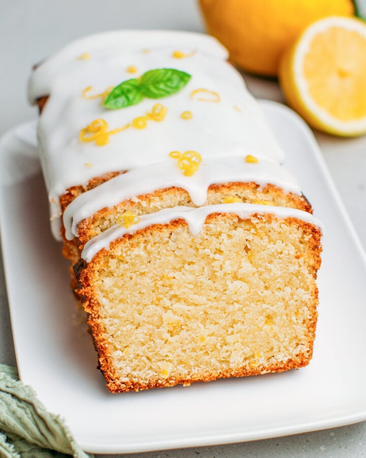 Lemon pound cake topped with lemon zest and basil leaves.