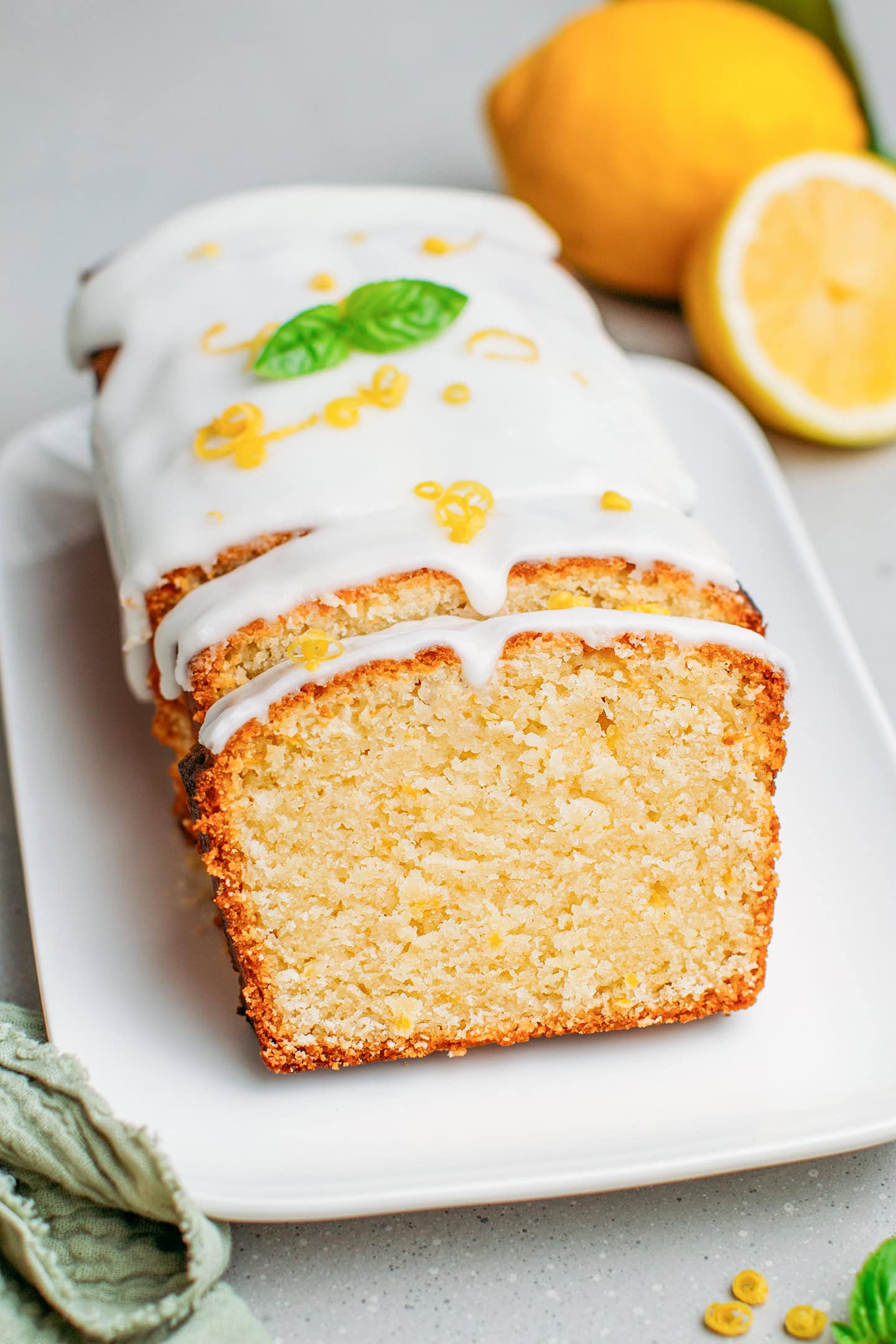 Lemon pound cake topped with lemon zest and basil leaves.