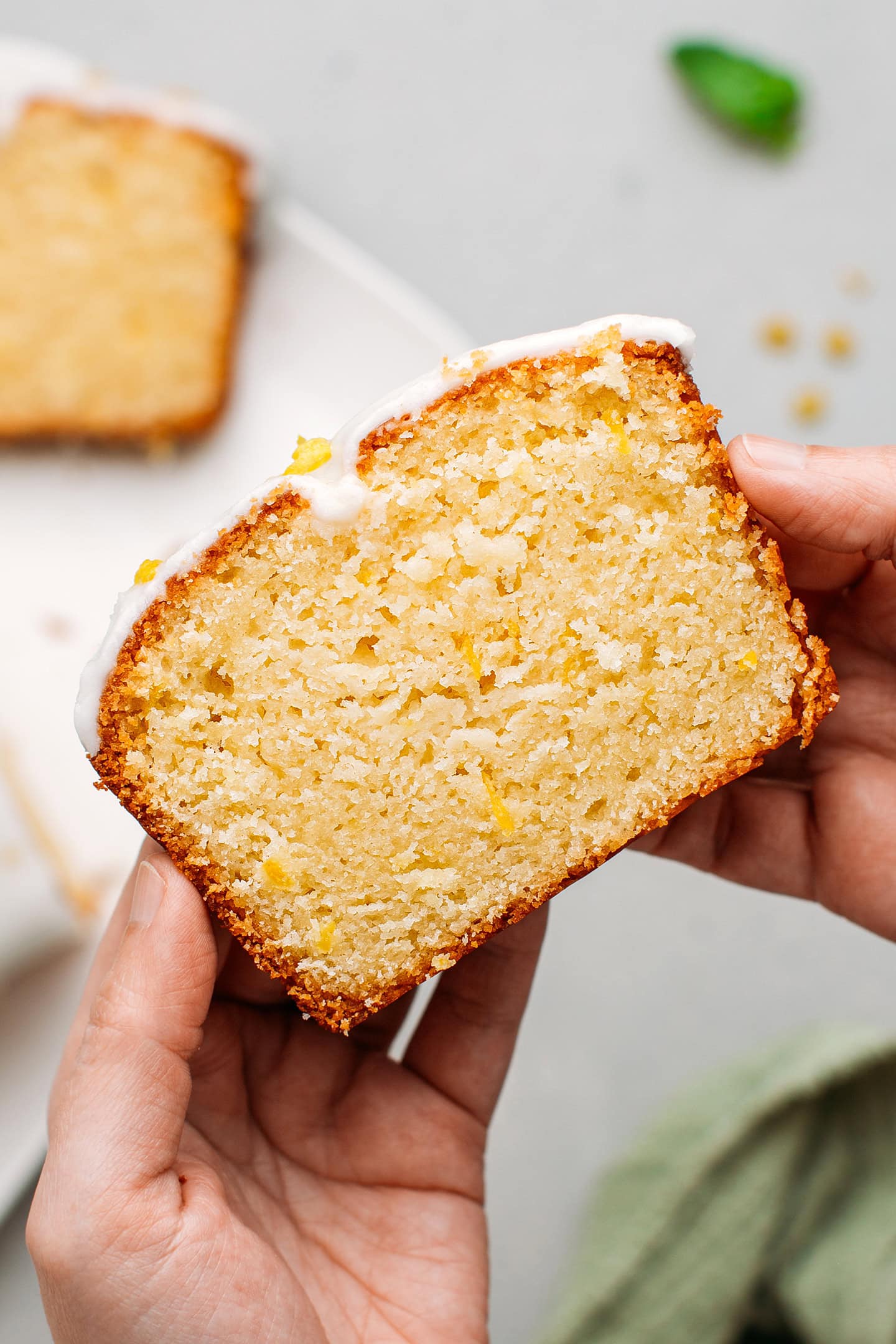 Holding a slice of lemon pound cake.