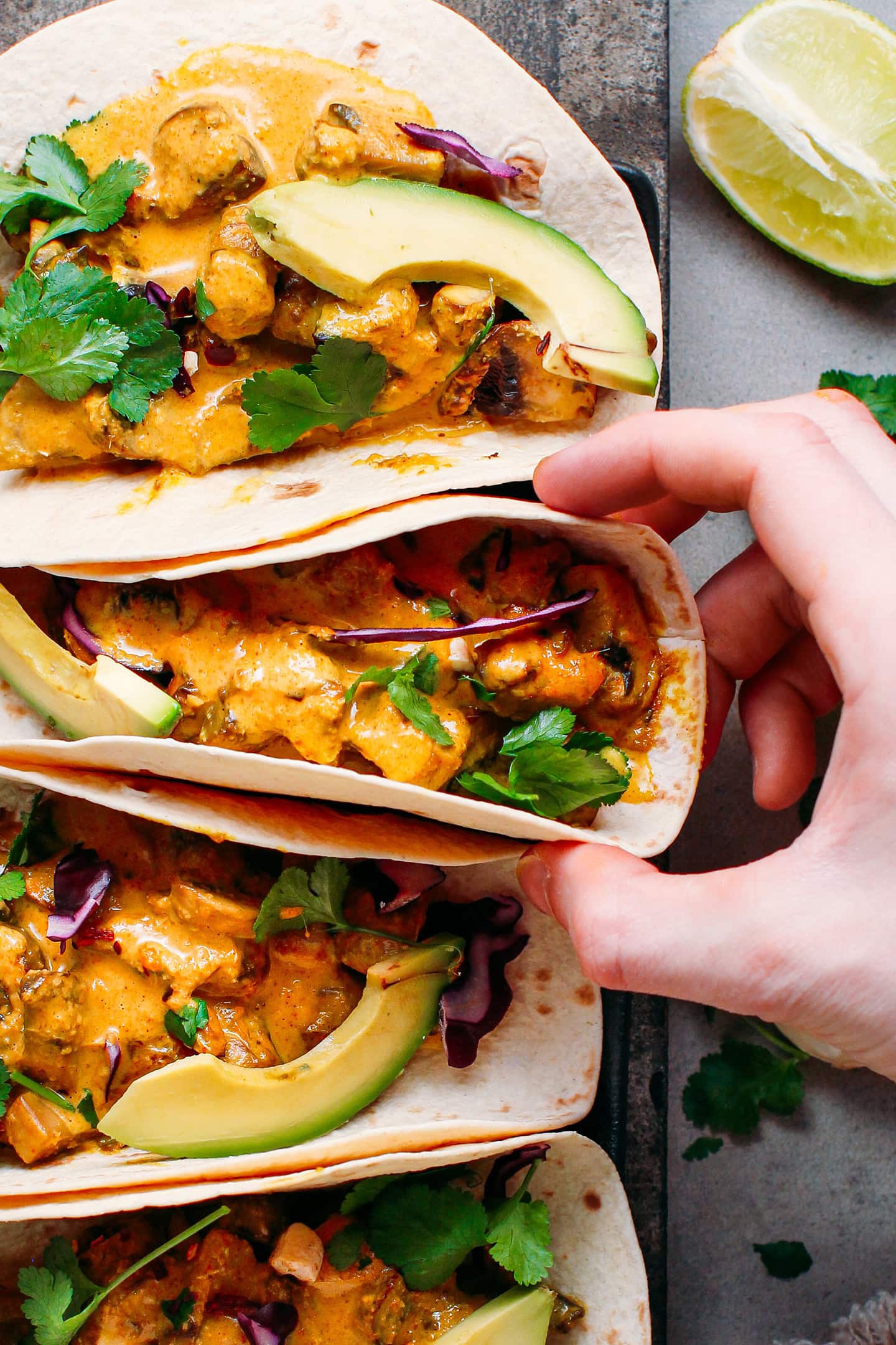 Holding a tortilla filled with curried mushrooms.