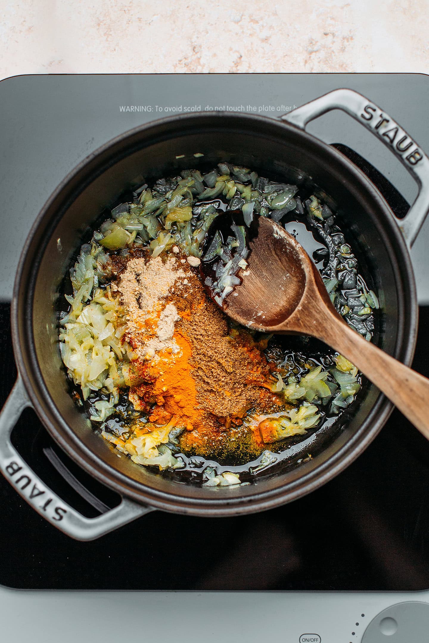 Sautéed onions and spices in a pot.