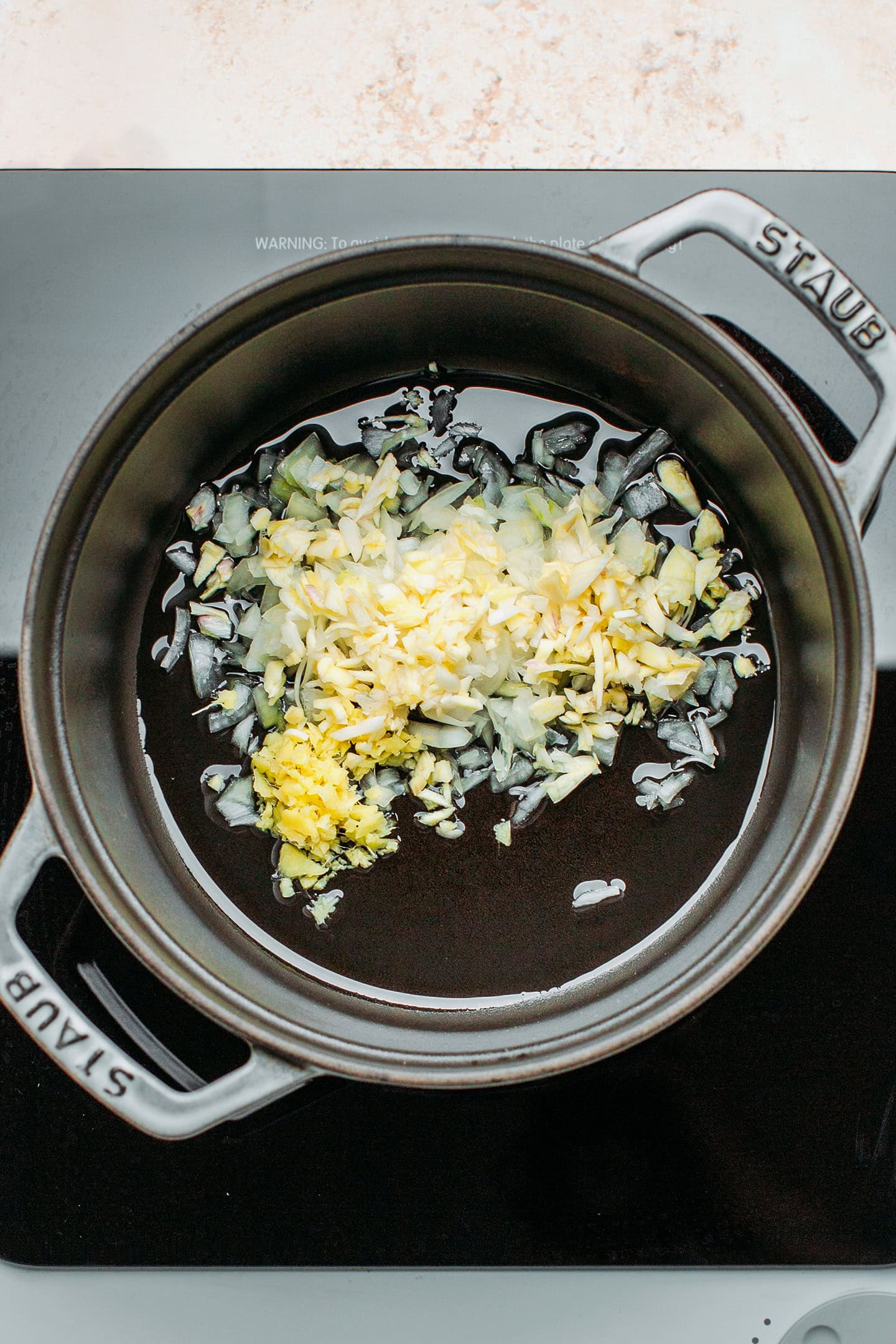 Minced onion, garlic, and ginger in a pot.