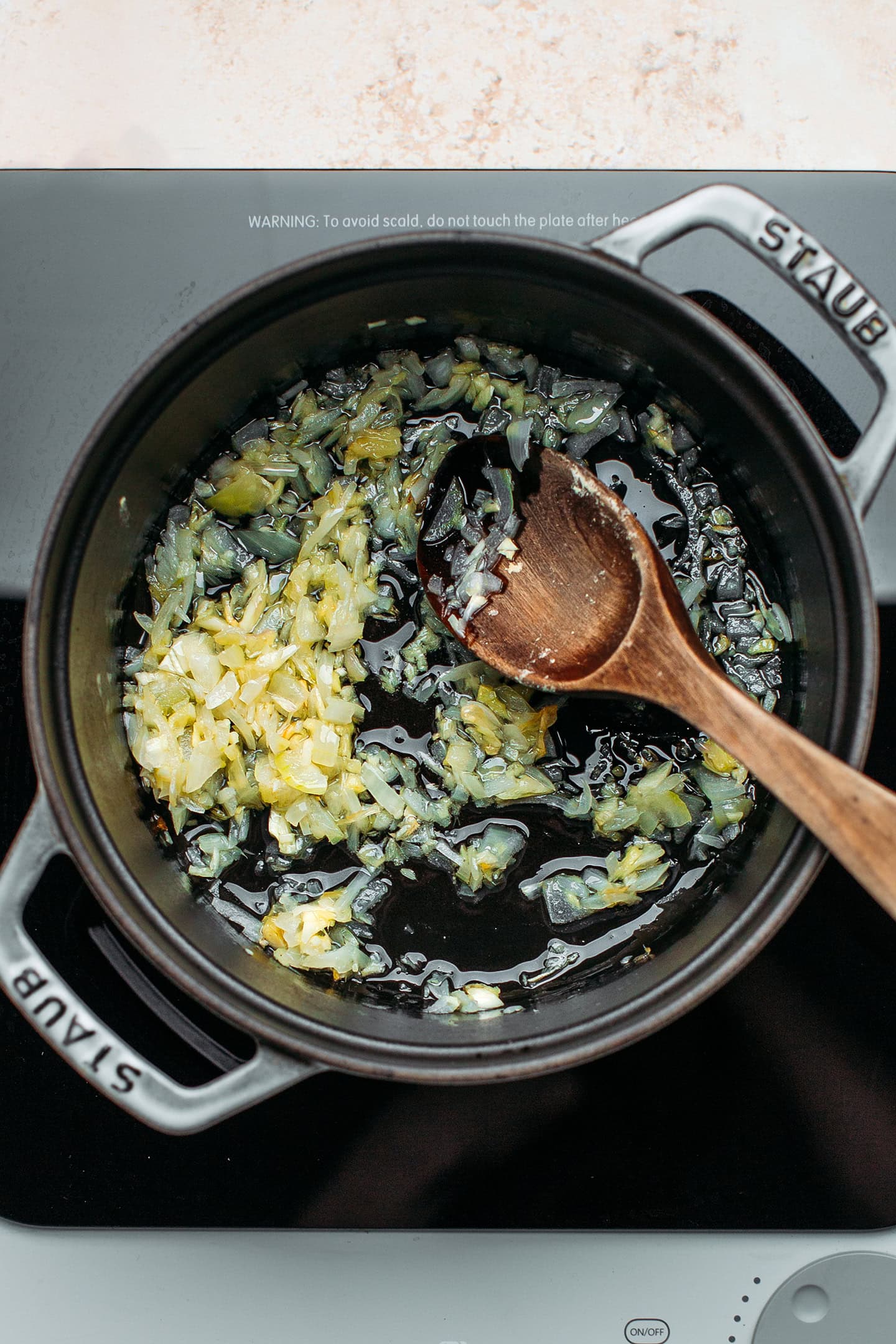 Sautéed onions, garlic, and ginger in a pot.