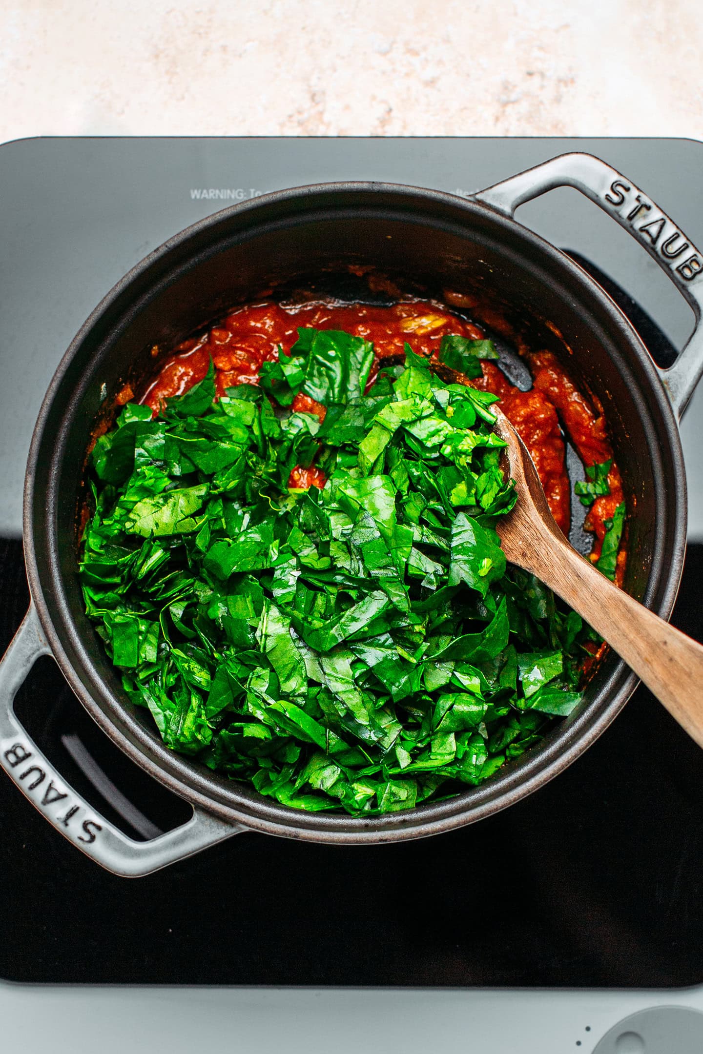 Tomatoes and chopped spinach in a pot.