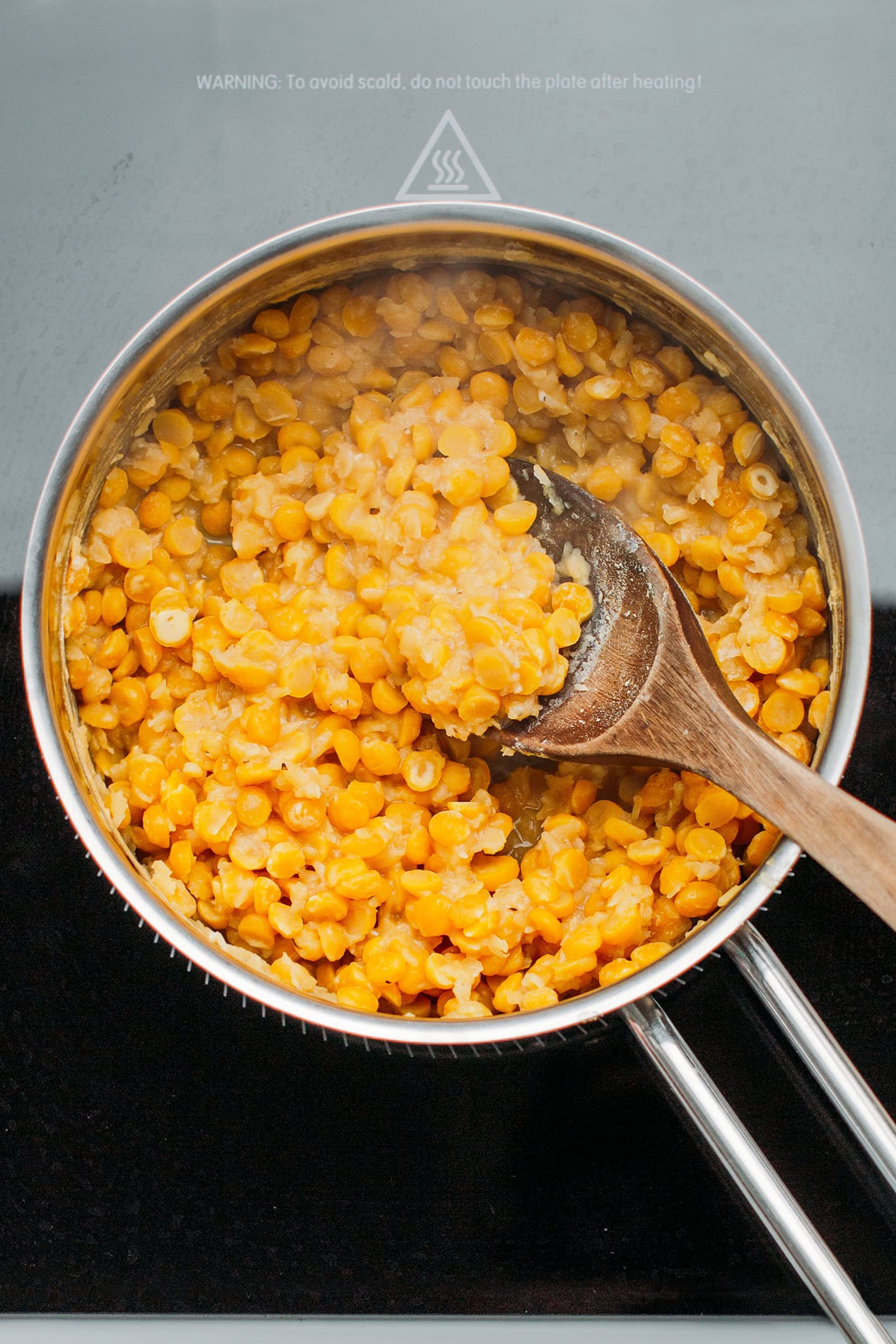 Cooked split chickpeas and red lentils in a saucepan.