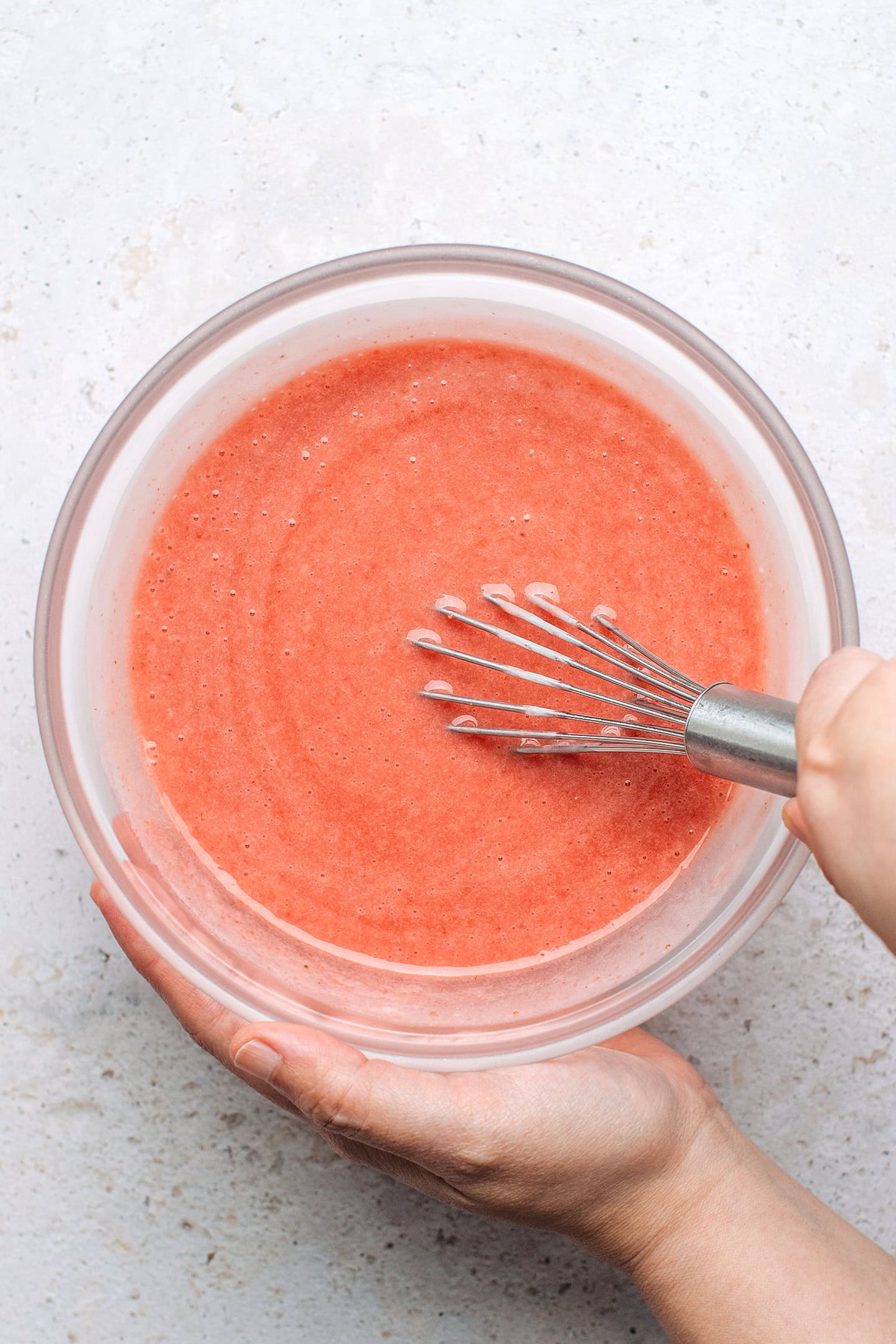 Whisking blended strawberries with coconut cream.