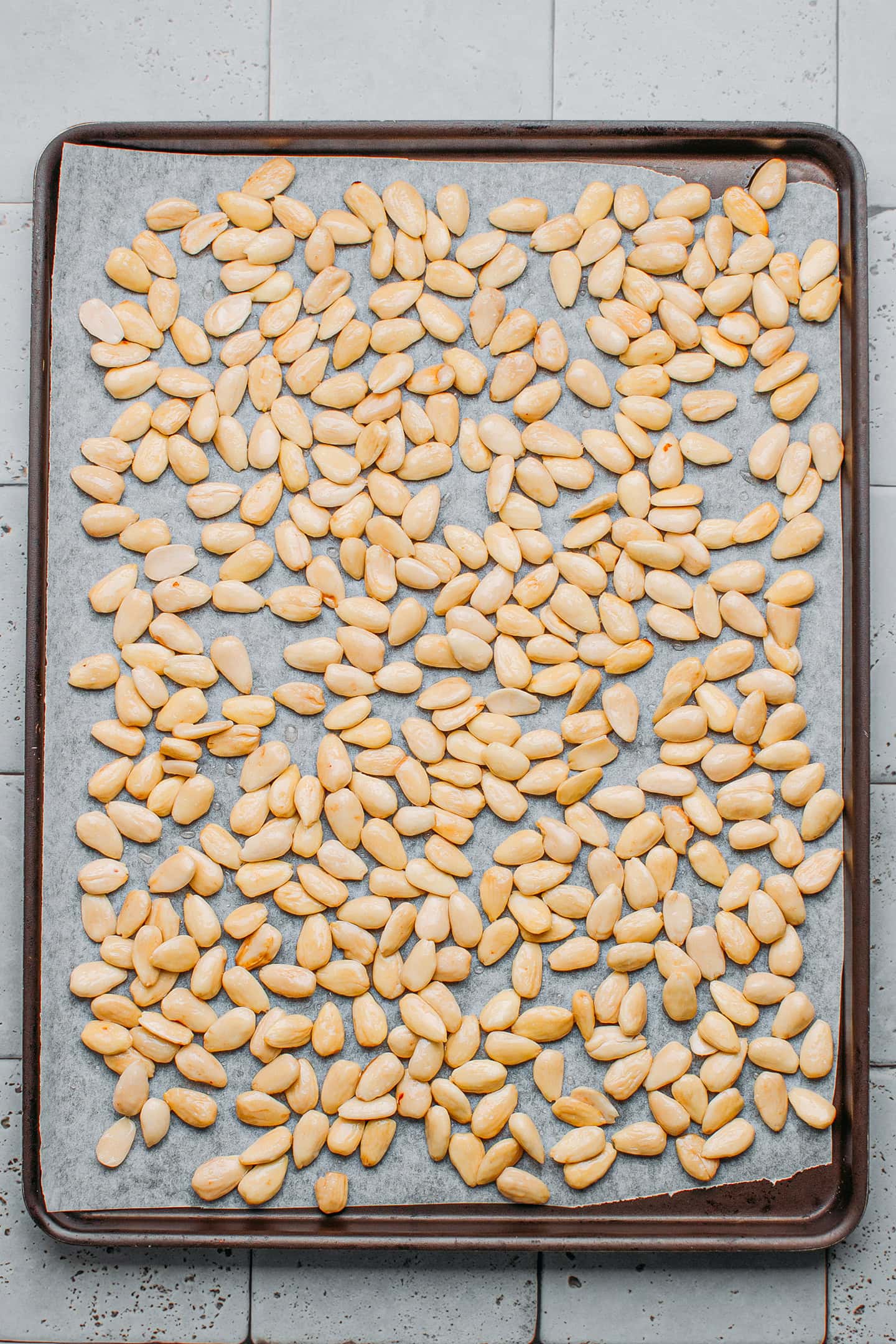 Blanched almonds on a baking sheet.