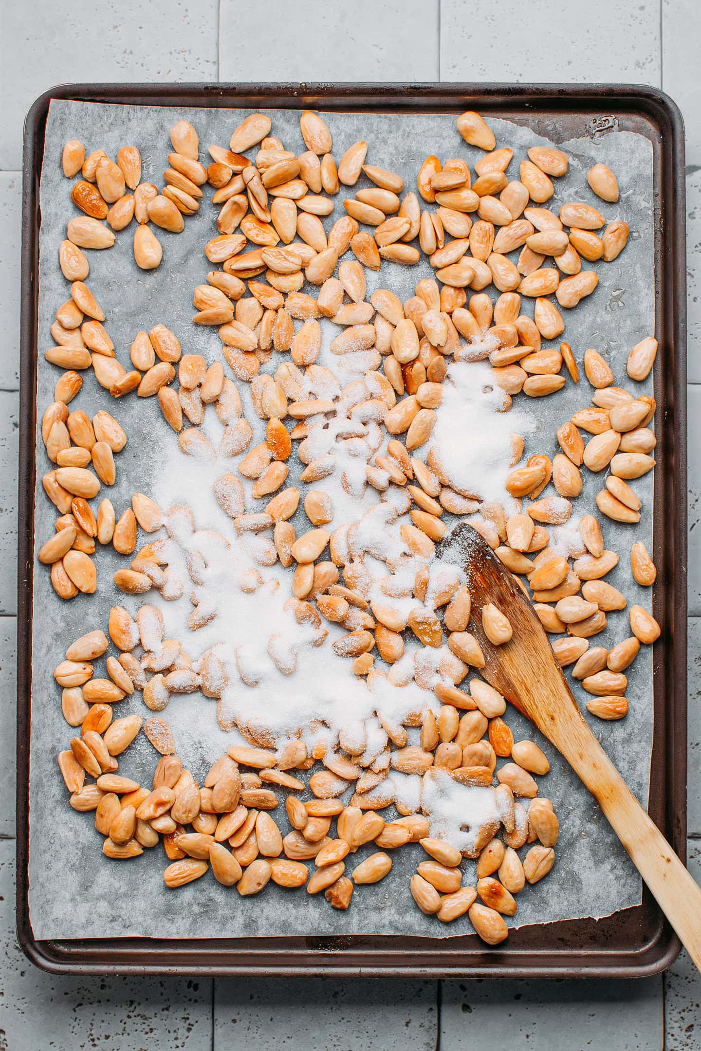 Roasted almonds with sugar on a baking sheet.