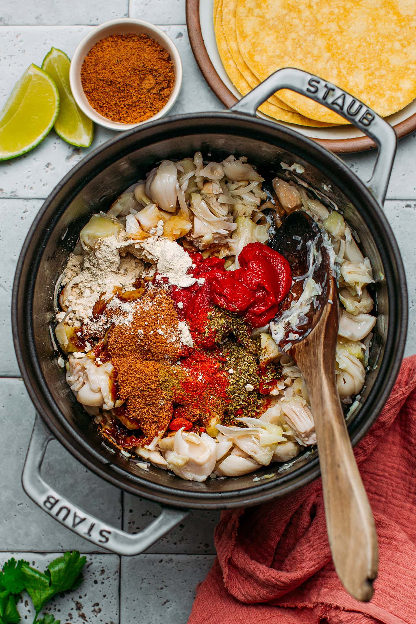 Pulled jackfruit, tomato paste, spices, and soy sauce in a pot.