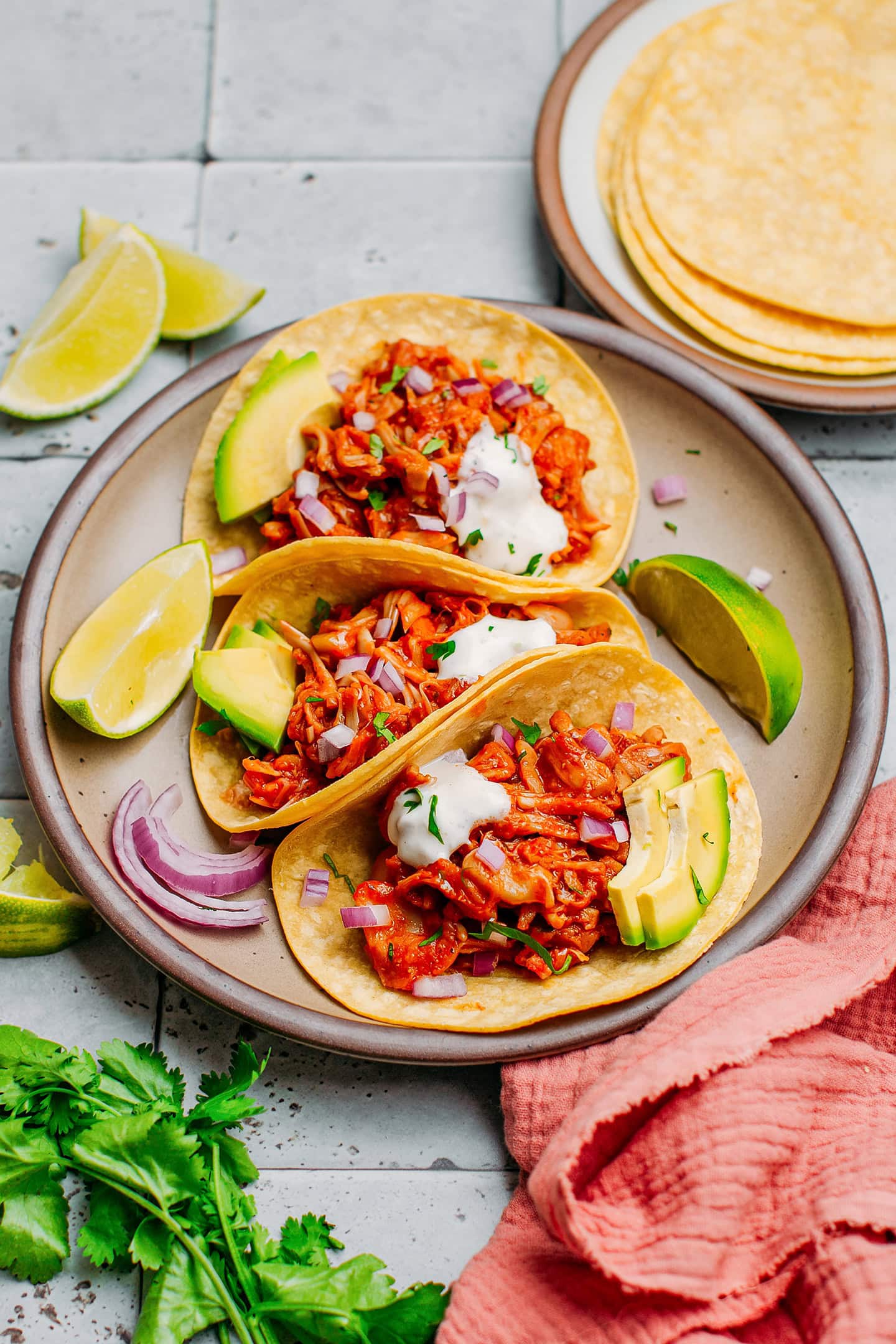 Three tacos filled with jackfruit on a plate.