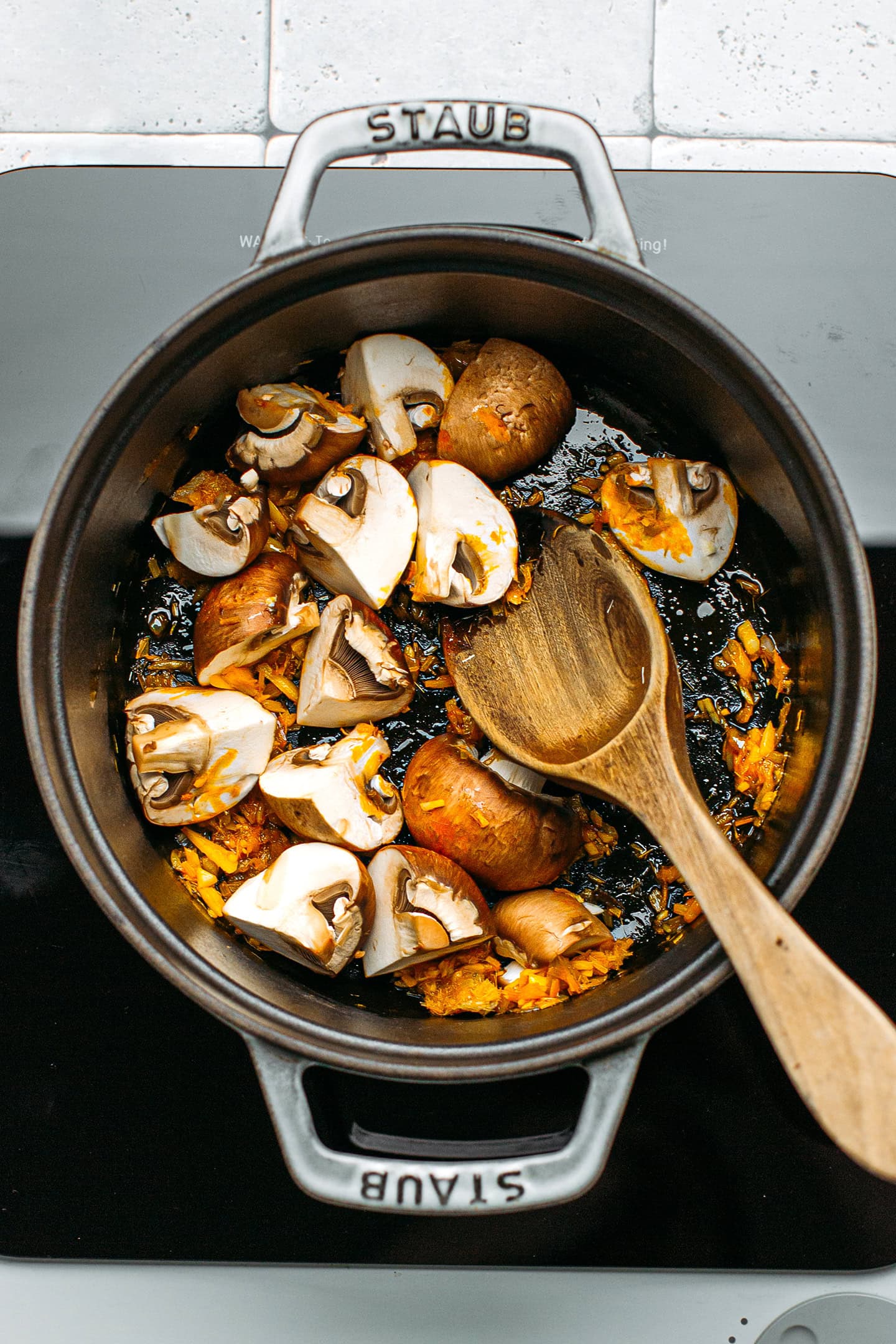 Sautéed mushrooms and lemongrass in a pot.