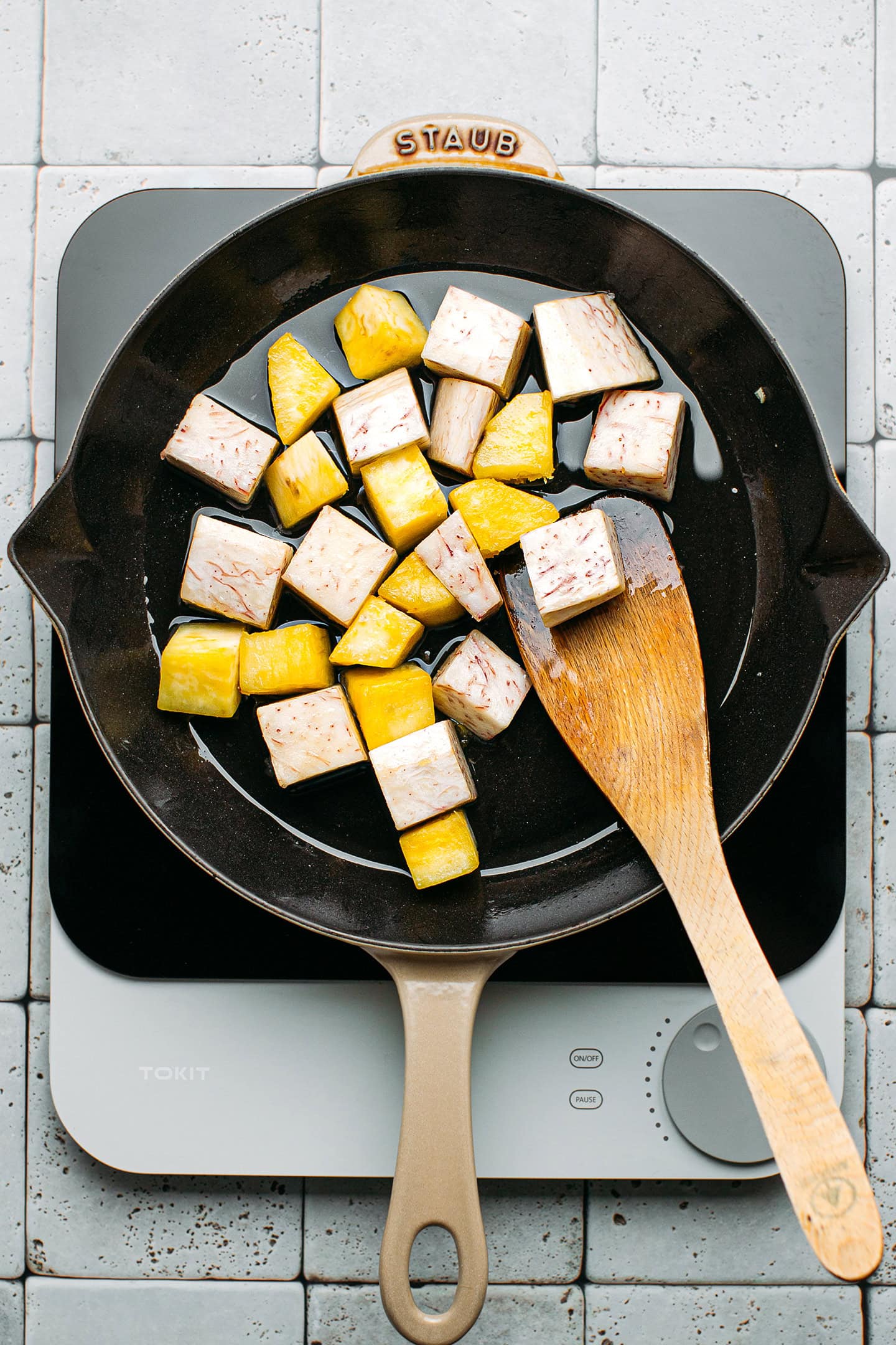 Sautéed taro and sweet potatoes in a pan.