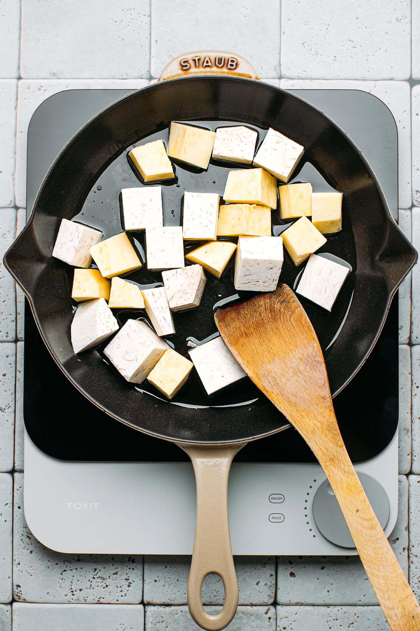 Cubed taro and sweet potatoes in a pan.